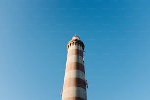 Ein hoher Leuchtturm mit blauem Himmel im Hintergrund