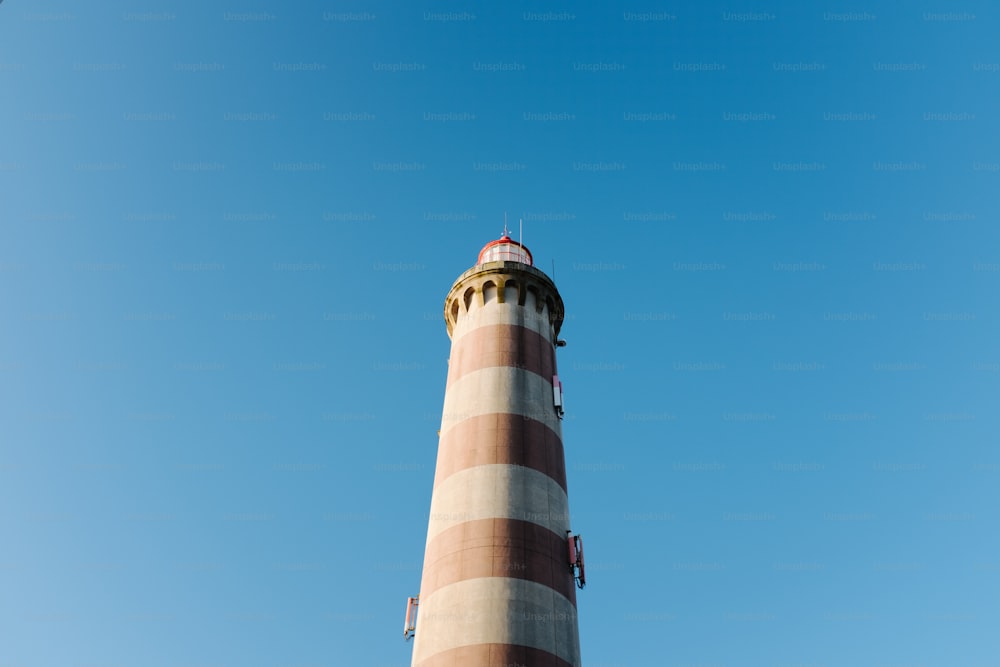 Ein hoher Leuchtturm mit blauem Himmel im Hintergrund