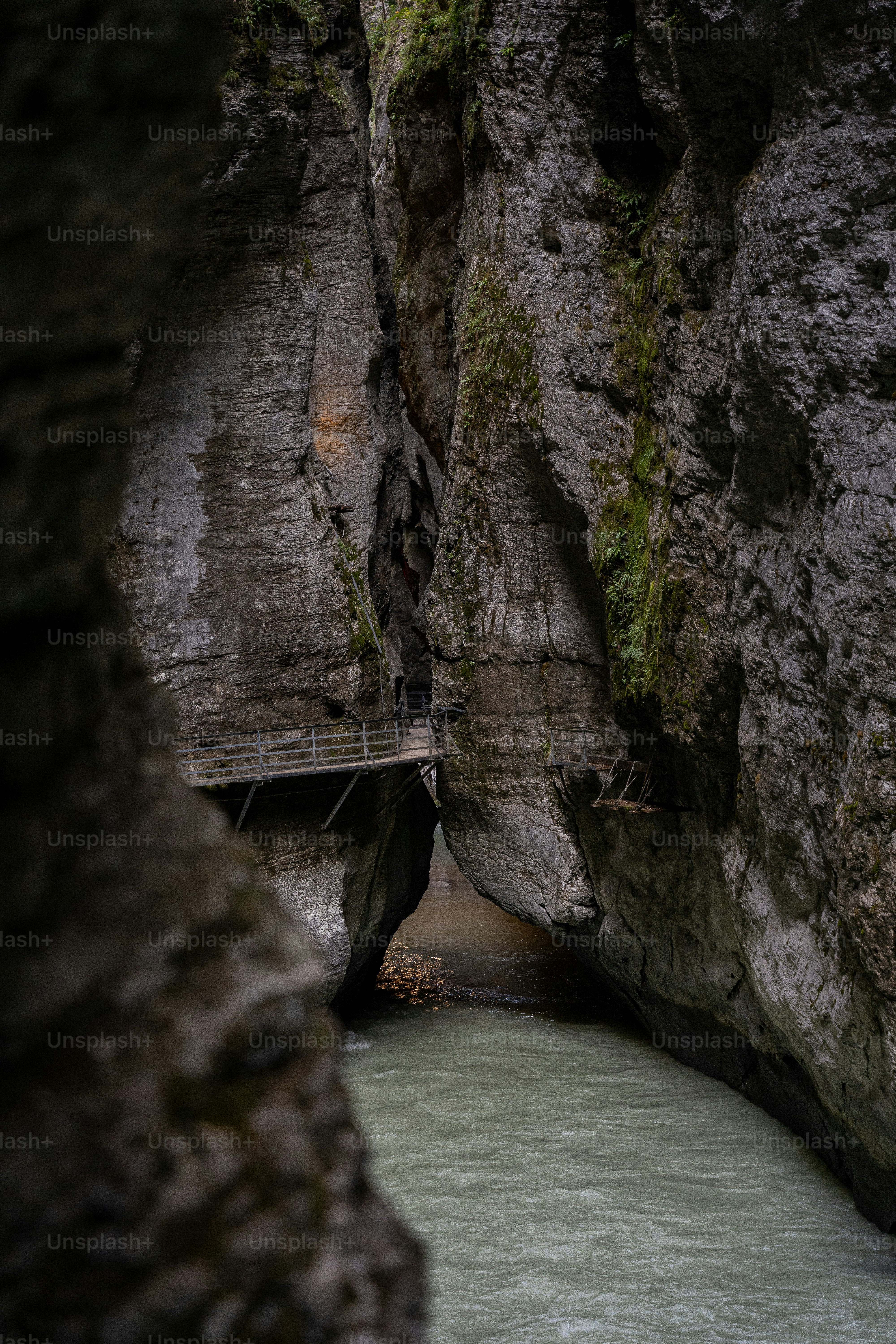a man walking across a bridge over a river