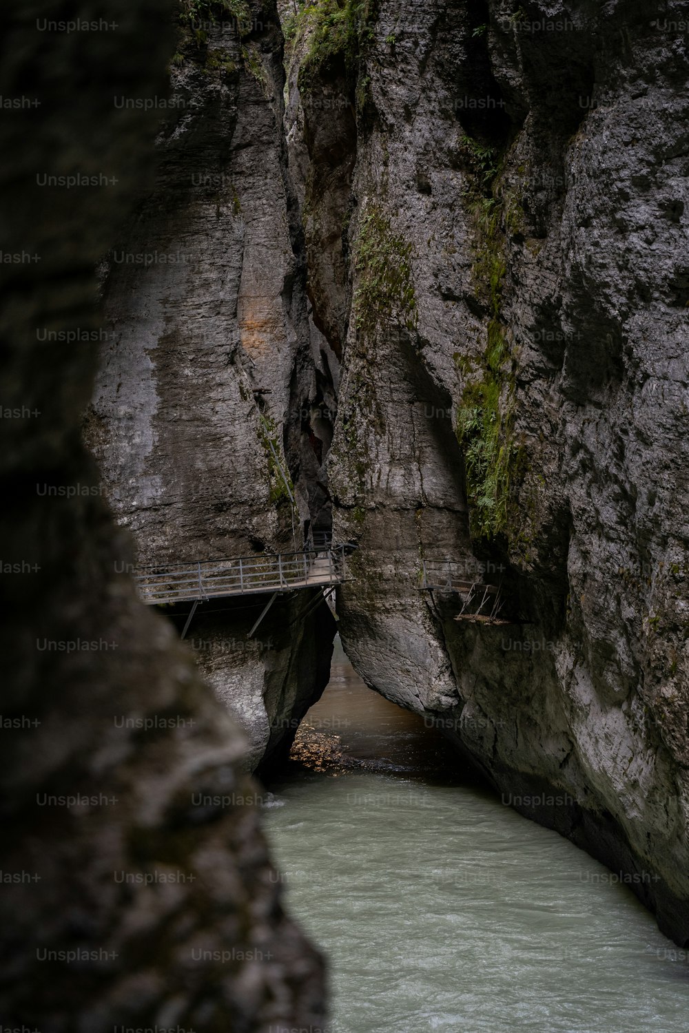 a man walking across a bridge over a river