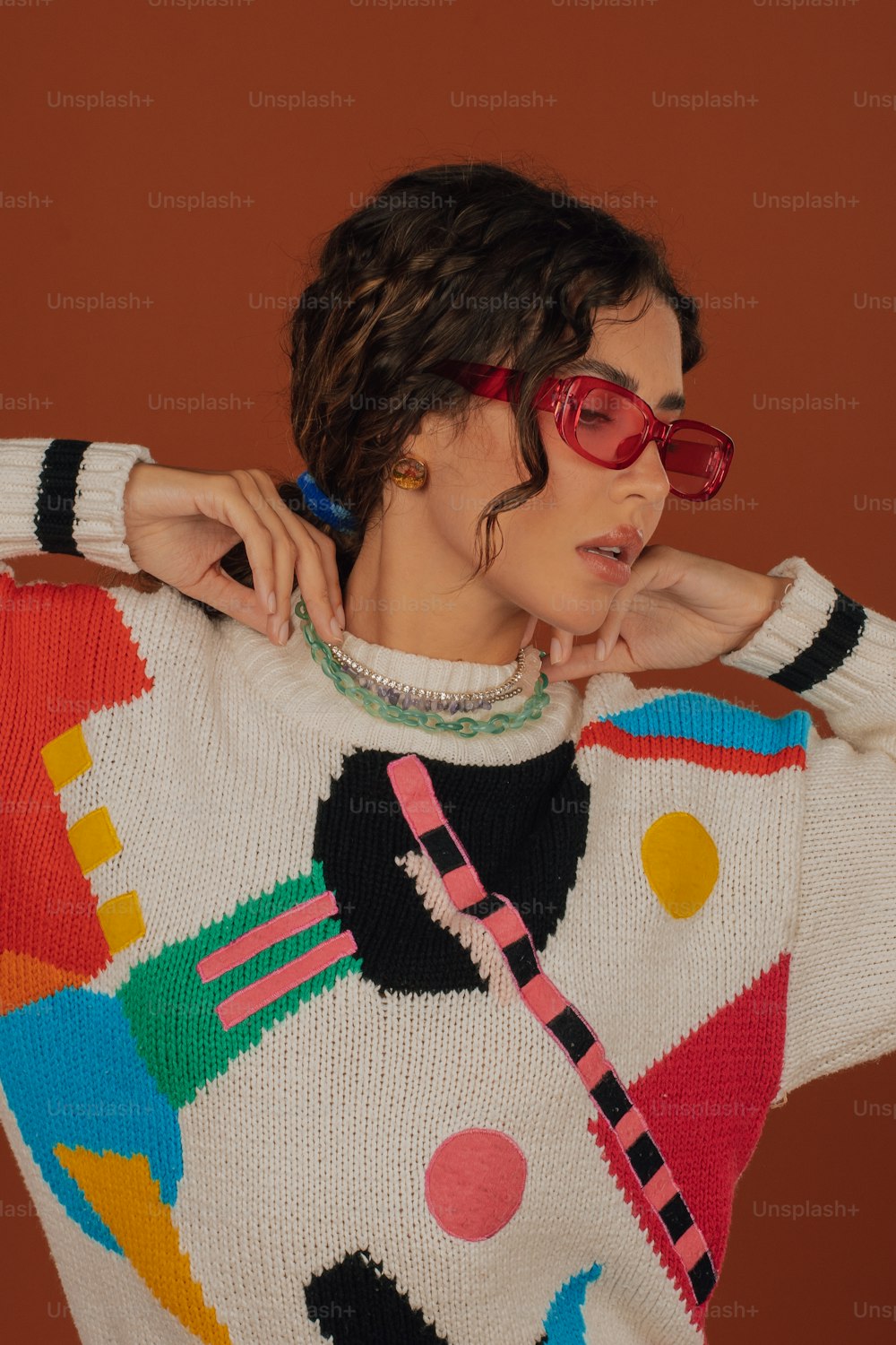 uma mulher vestindo um suéter colorido e óculos de sol