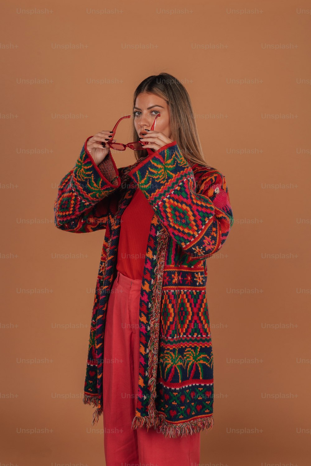 a woman in a red top and red pants poses for a picture