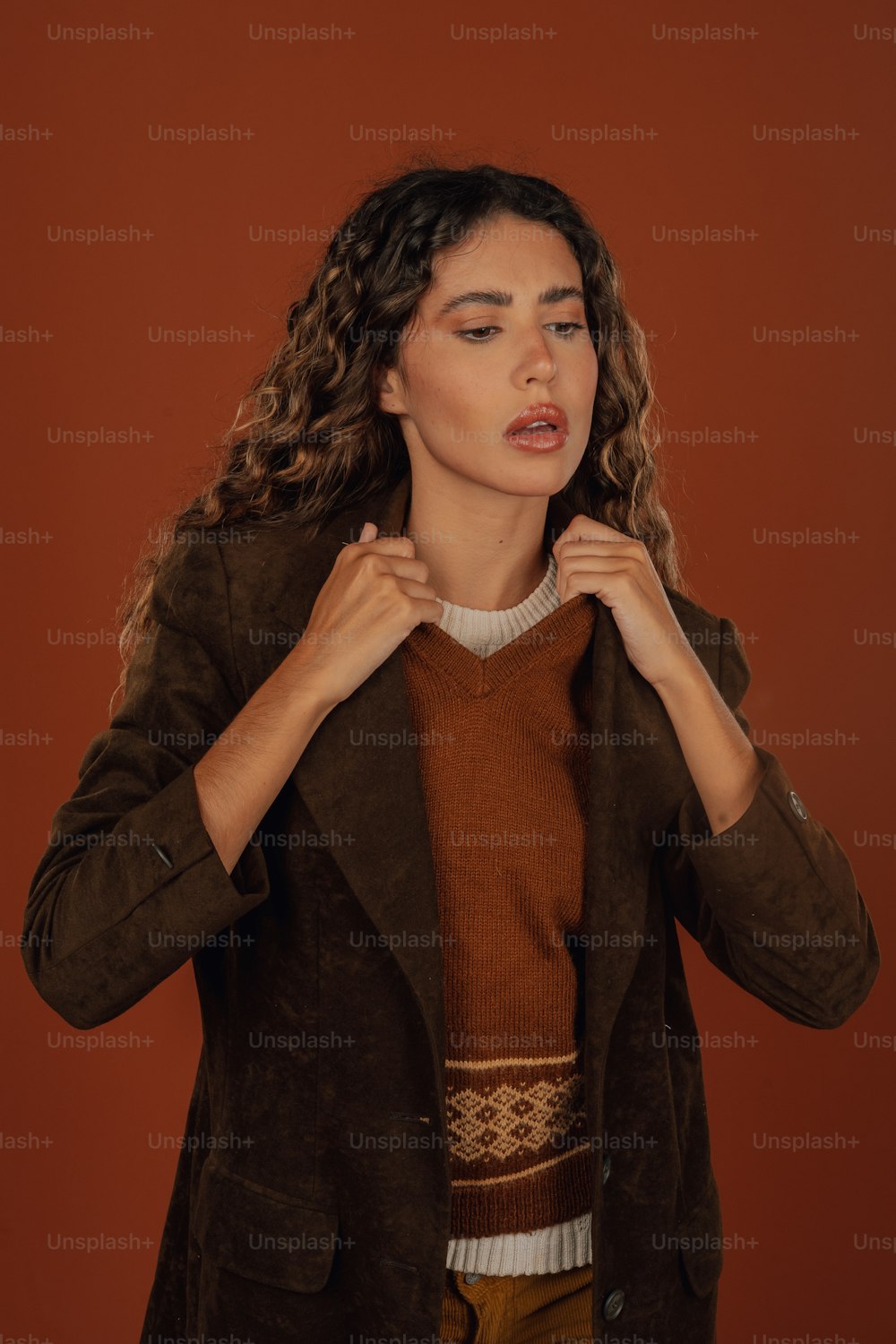 a woman in a brown jacket and a brown sweater