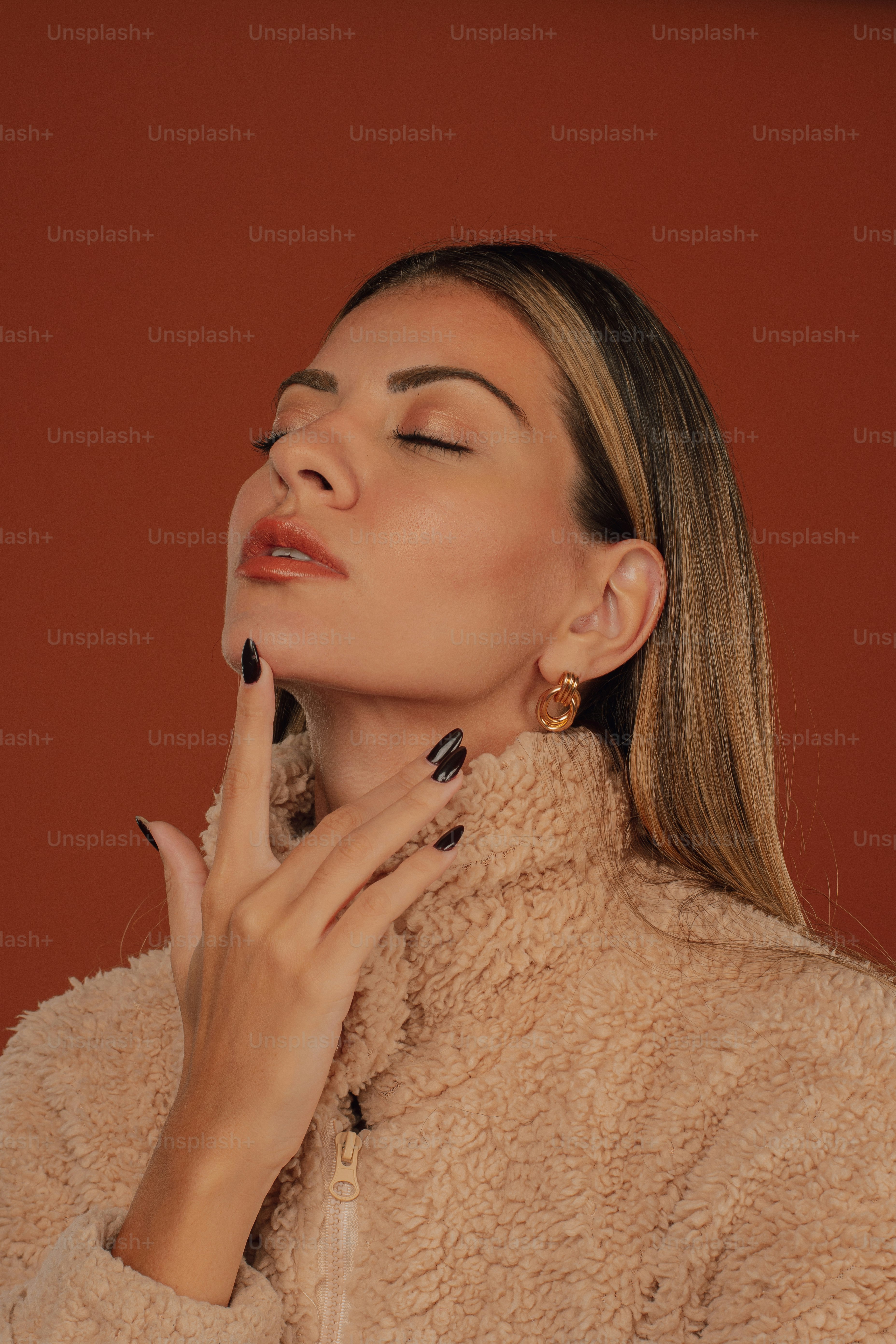 Une femme en manteau beige avec sa main sur le visage