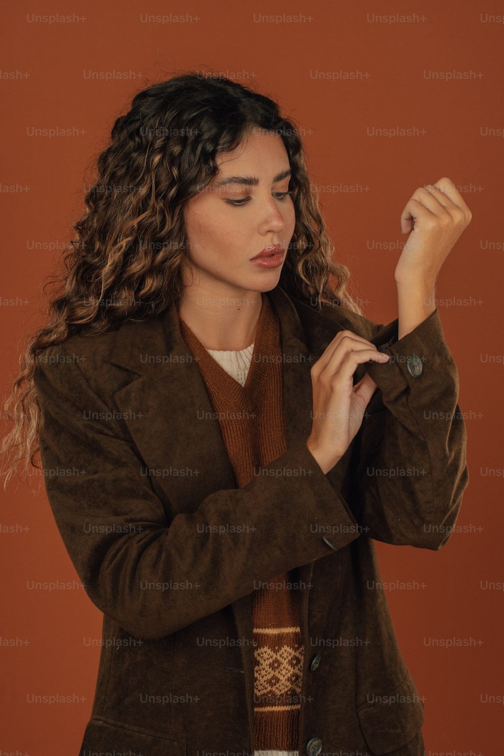 a woman in a brown jacket and a brown sweater