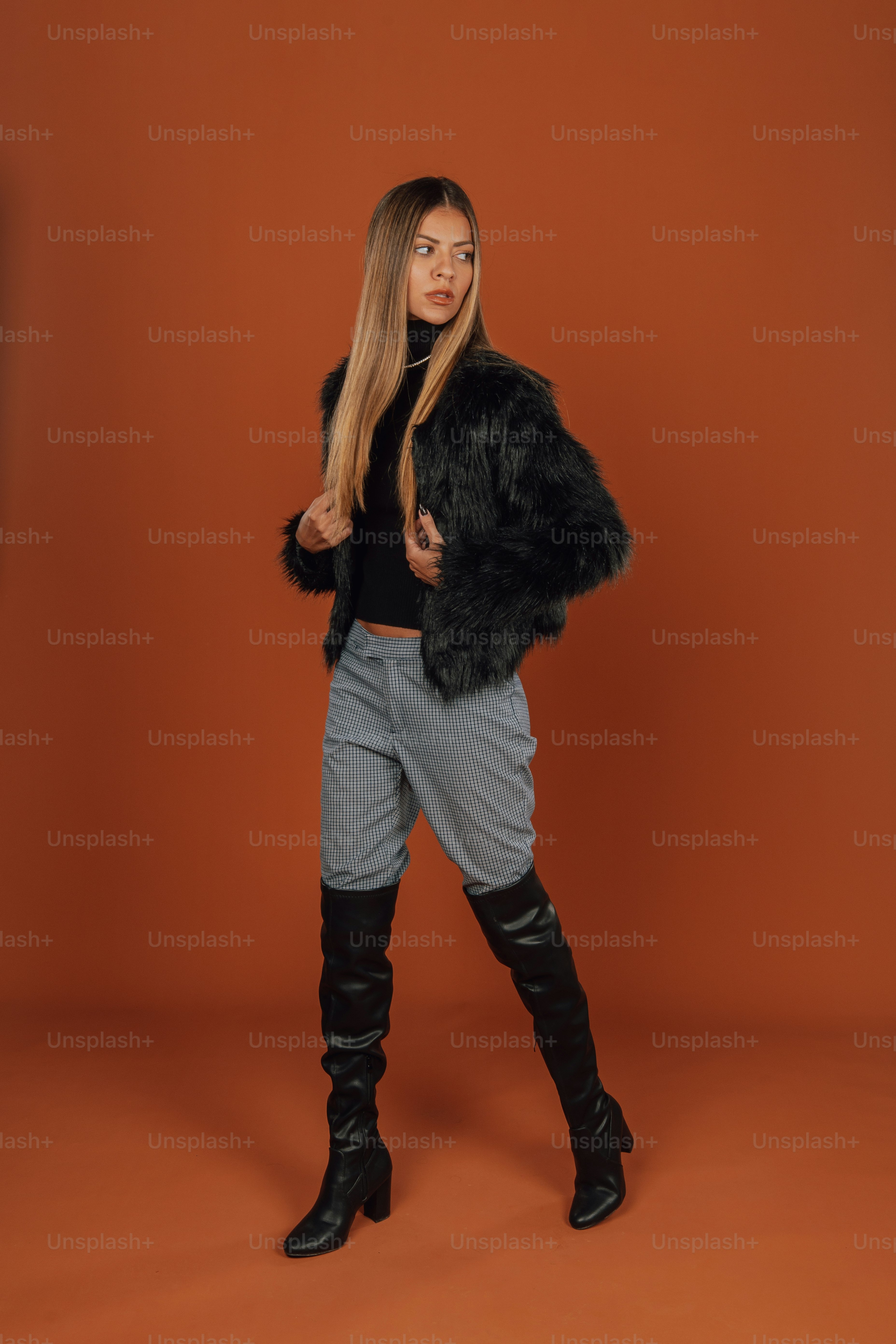 Una mujer con chaqueta negra y pantalones grises