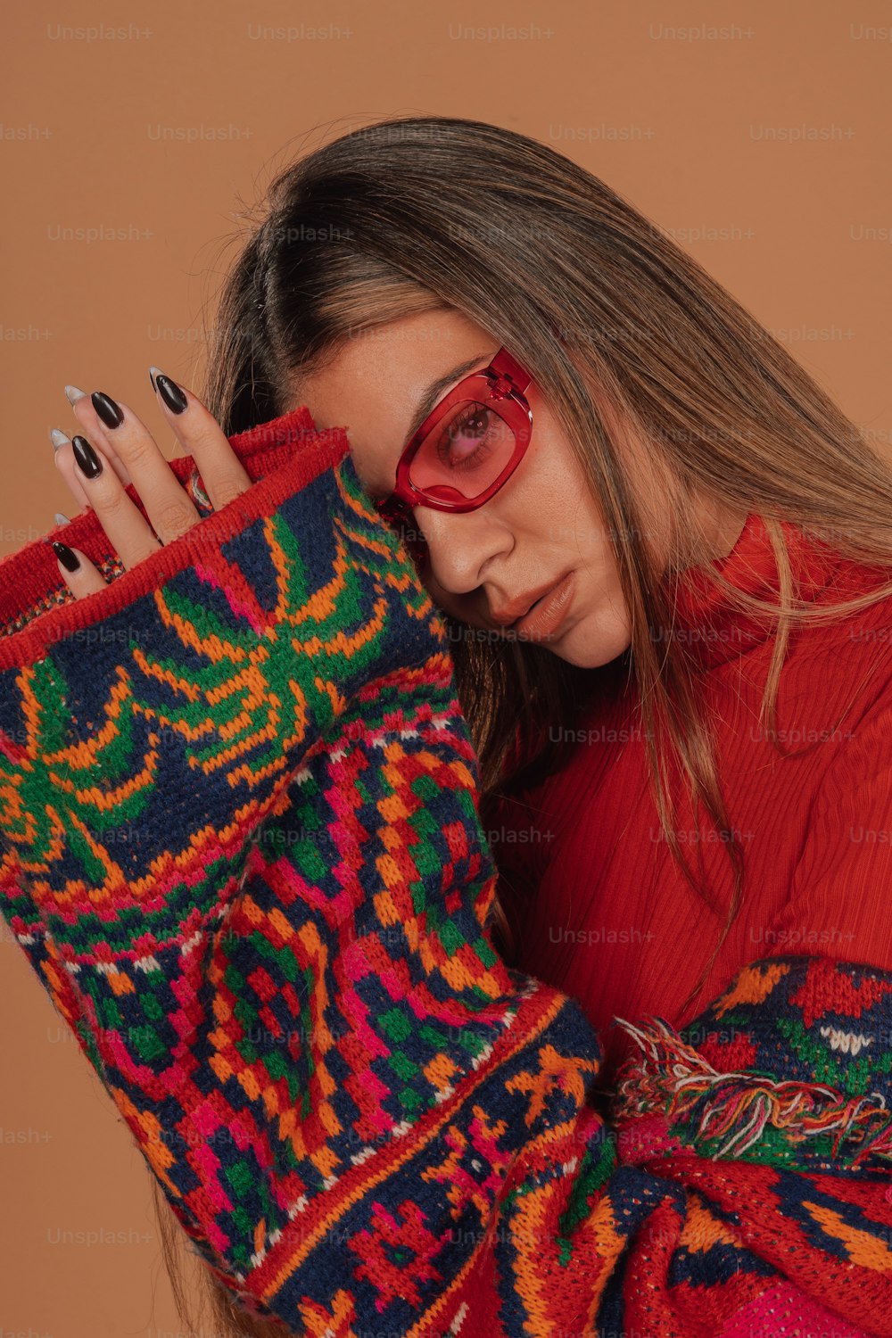 a woman wearing red glasses and a colorful sweater