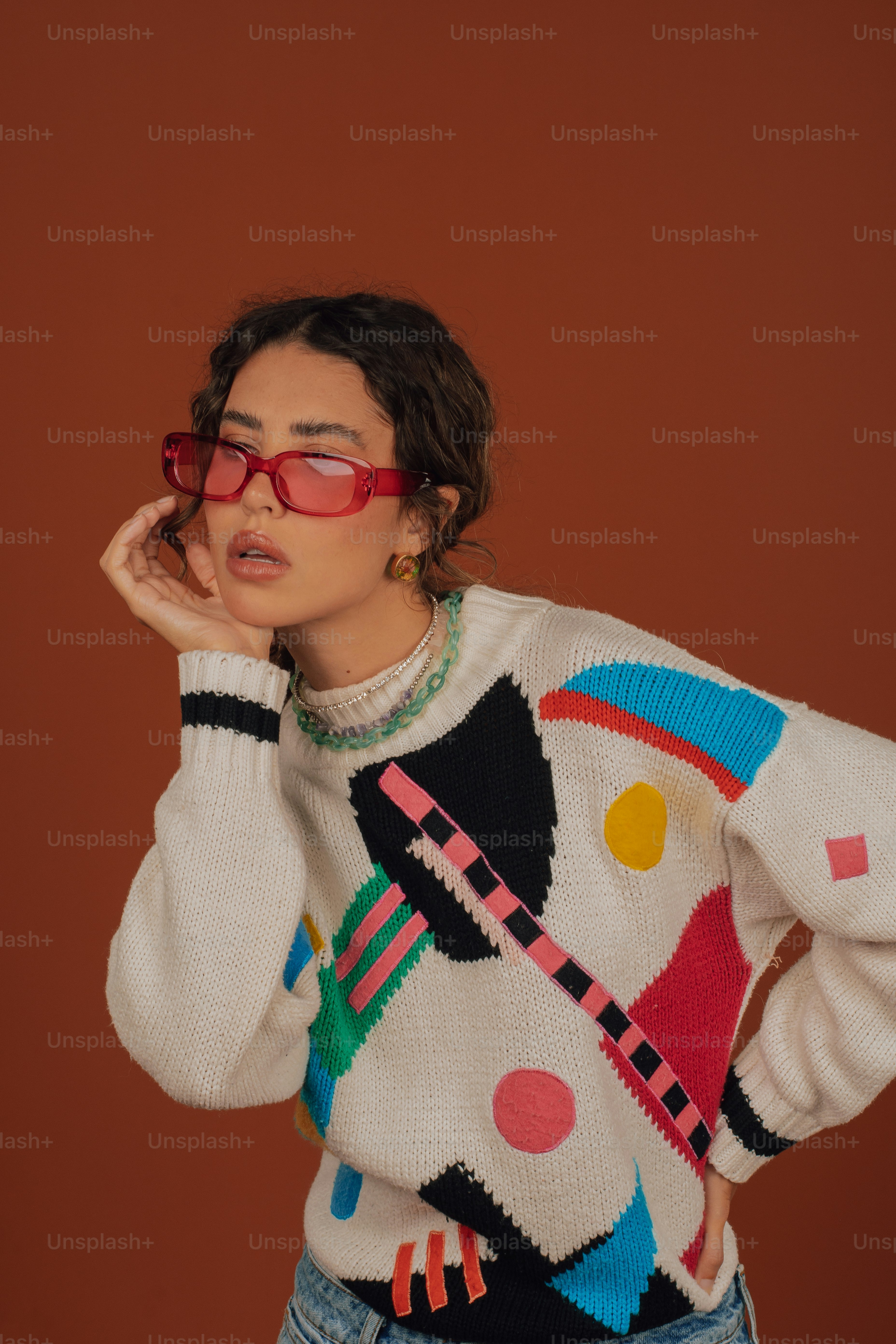 a woman in a sweater and glasses poses for a picture