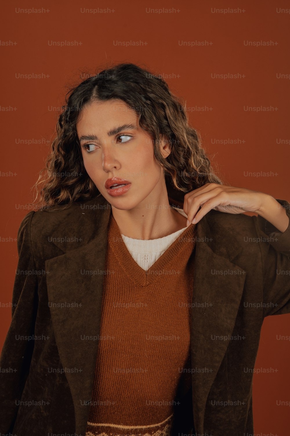 uma mulher em um suéter marrom e uma jaqueta marrom