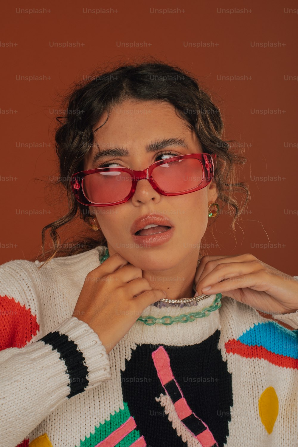 a woman wearing red glasses and a colorful sweater