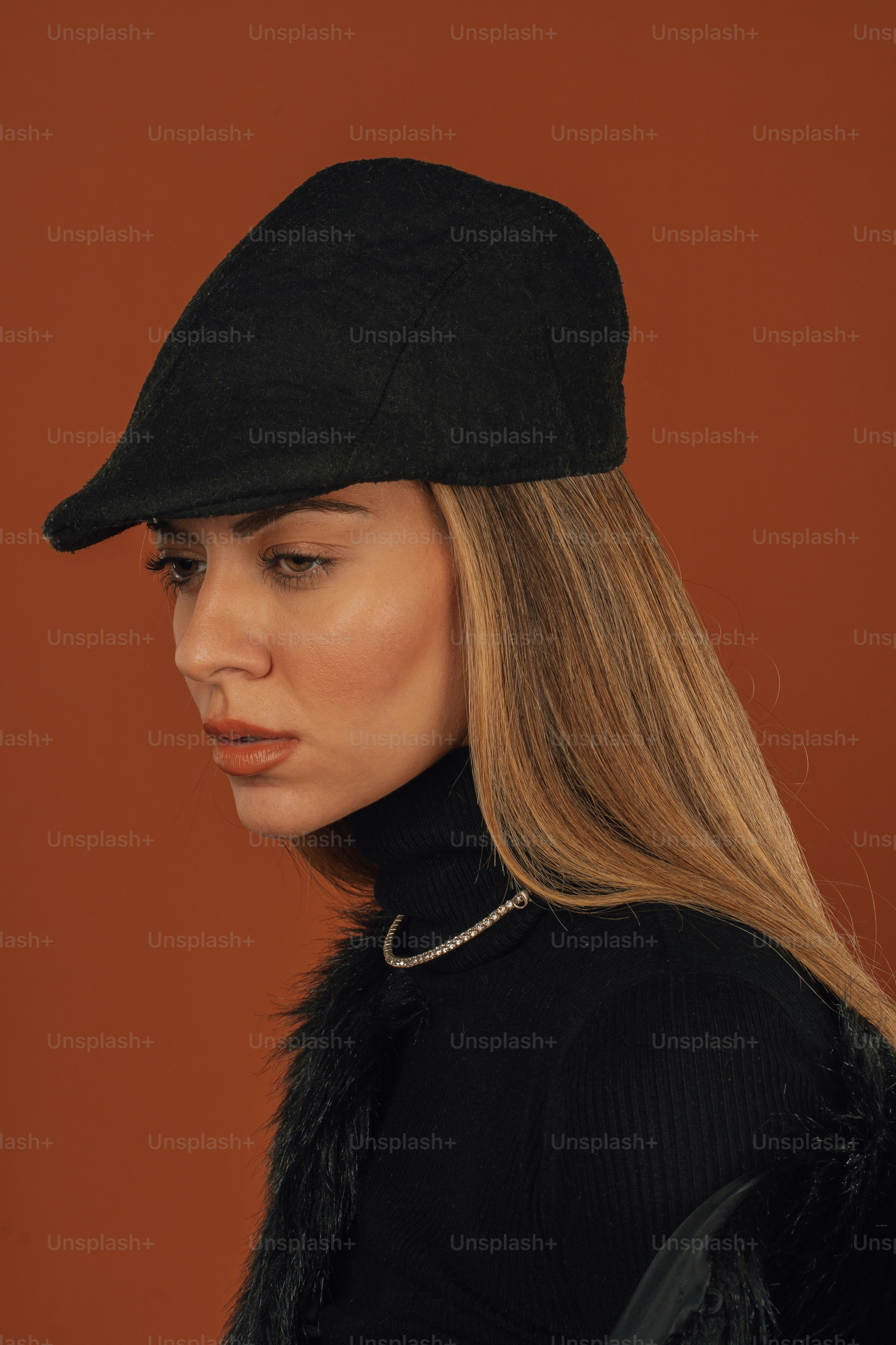 a woman wearing a black hat with a fur collar