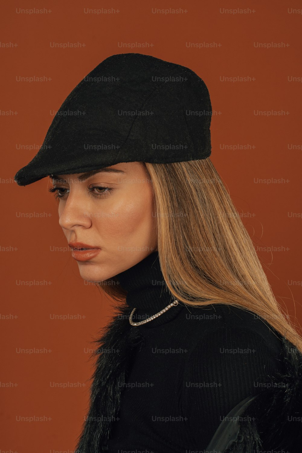 a woman wearing a black hat with a fur collar
