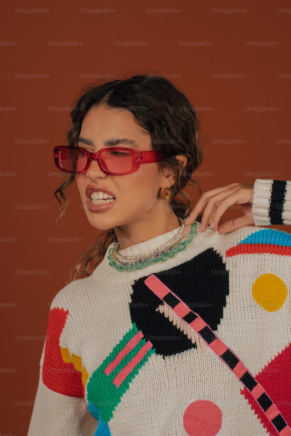 a woman wearing red glasses and a colorful sweater