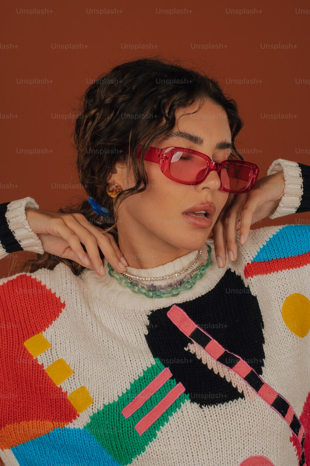 a woman wearing red glasses and a colorful sweater