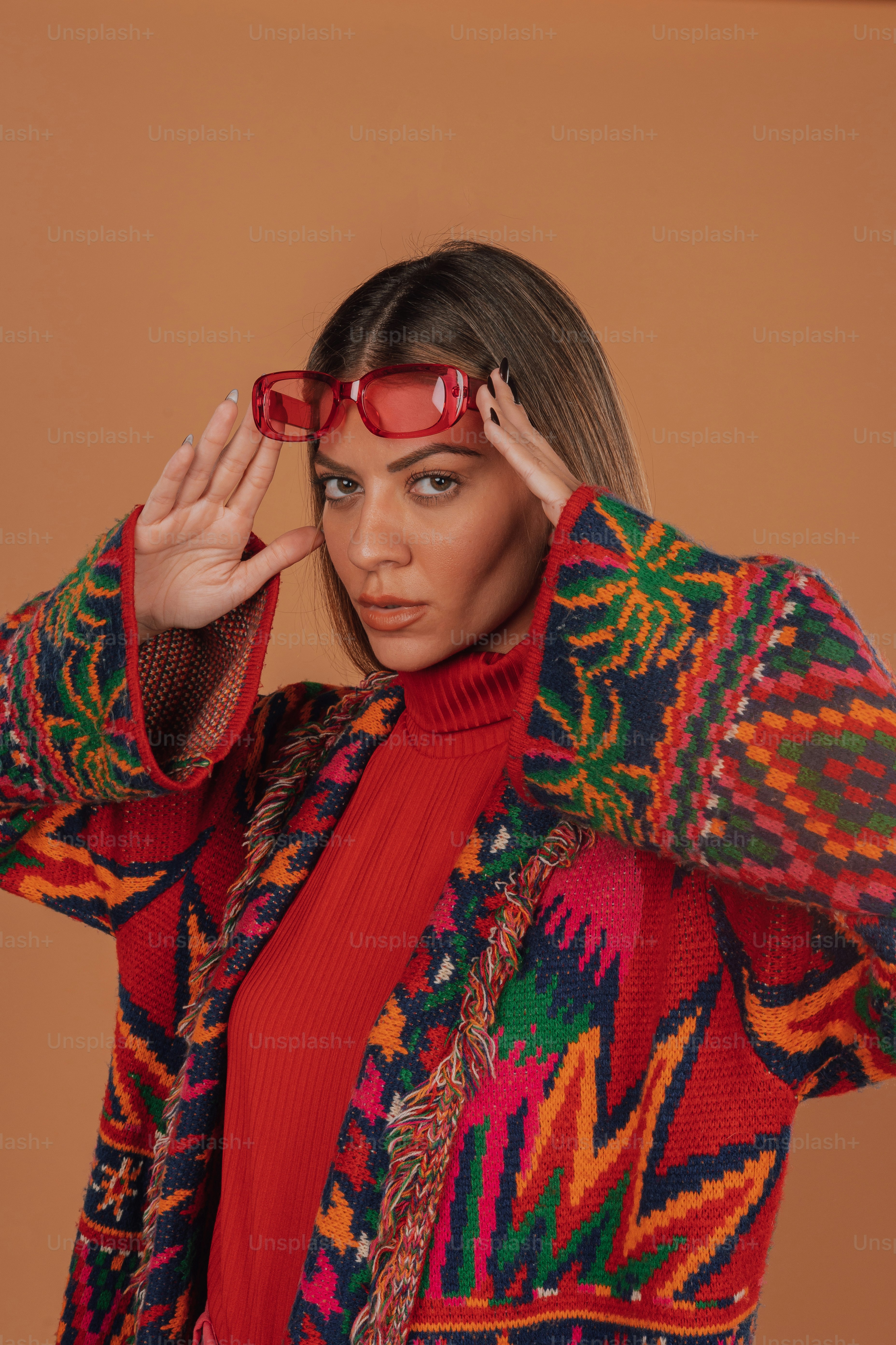 a woman wearing red glasses and a colorful sweater