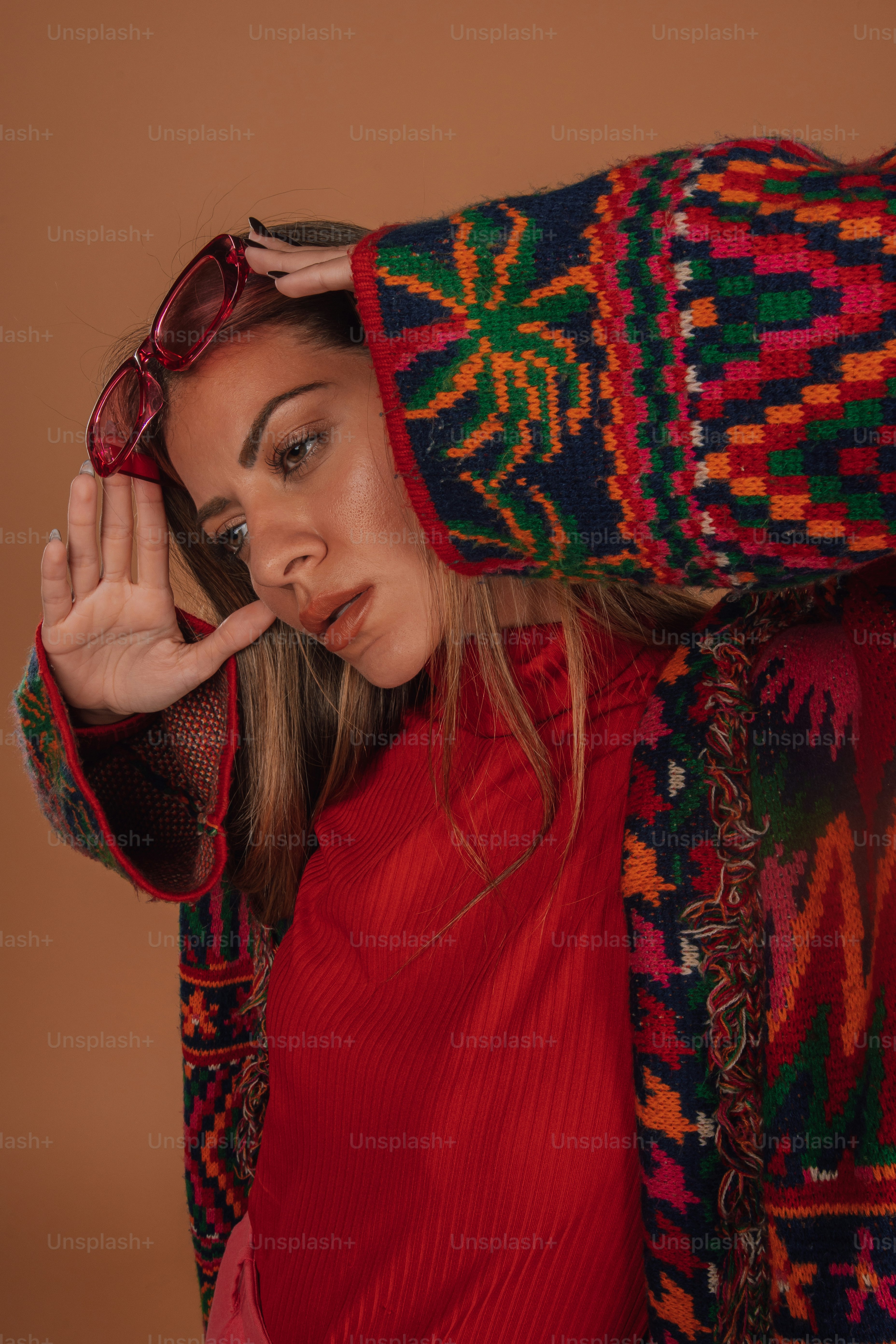 a woman in a red top is covering her face with a colorful blanket