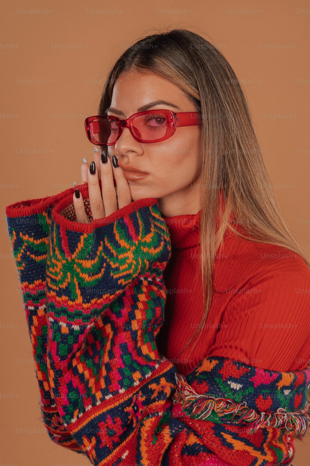 a woman wearing red glasses and a colorful sweater