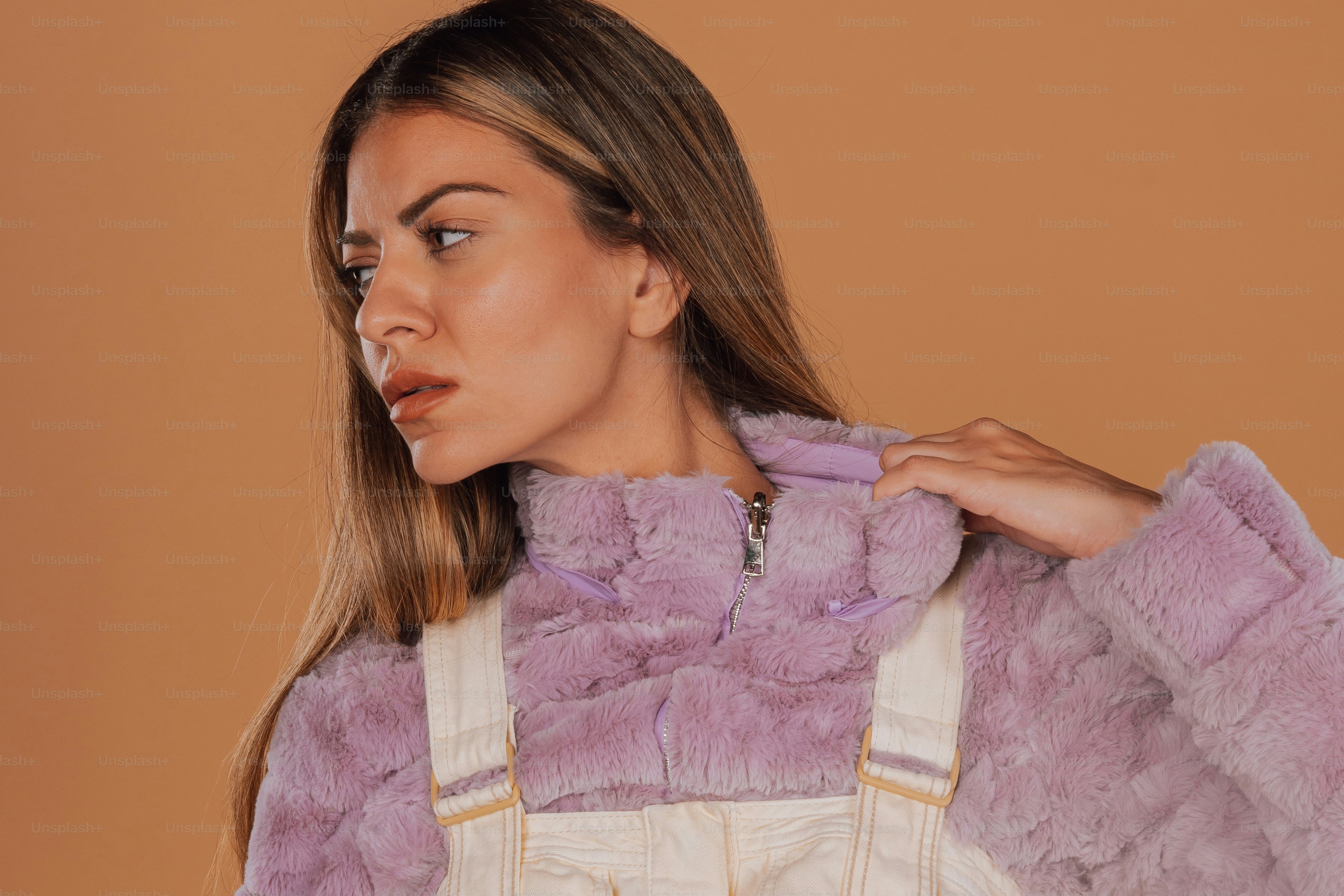 une femme vêtue d’un manteau de fourrure violet et d’une salopette