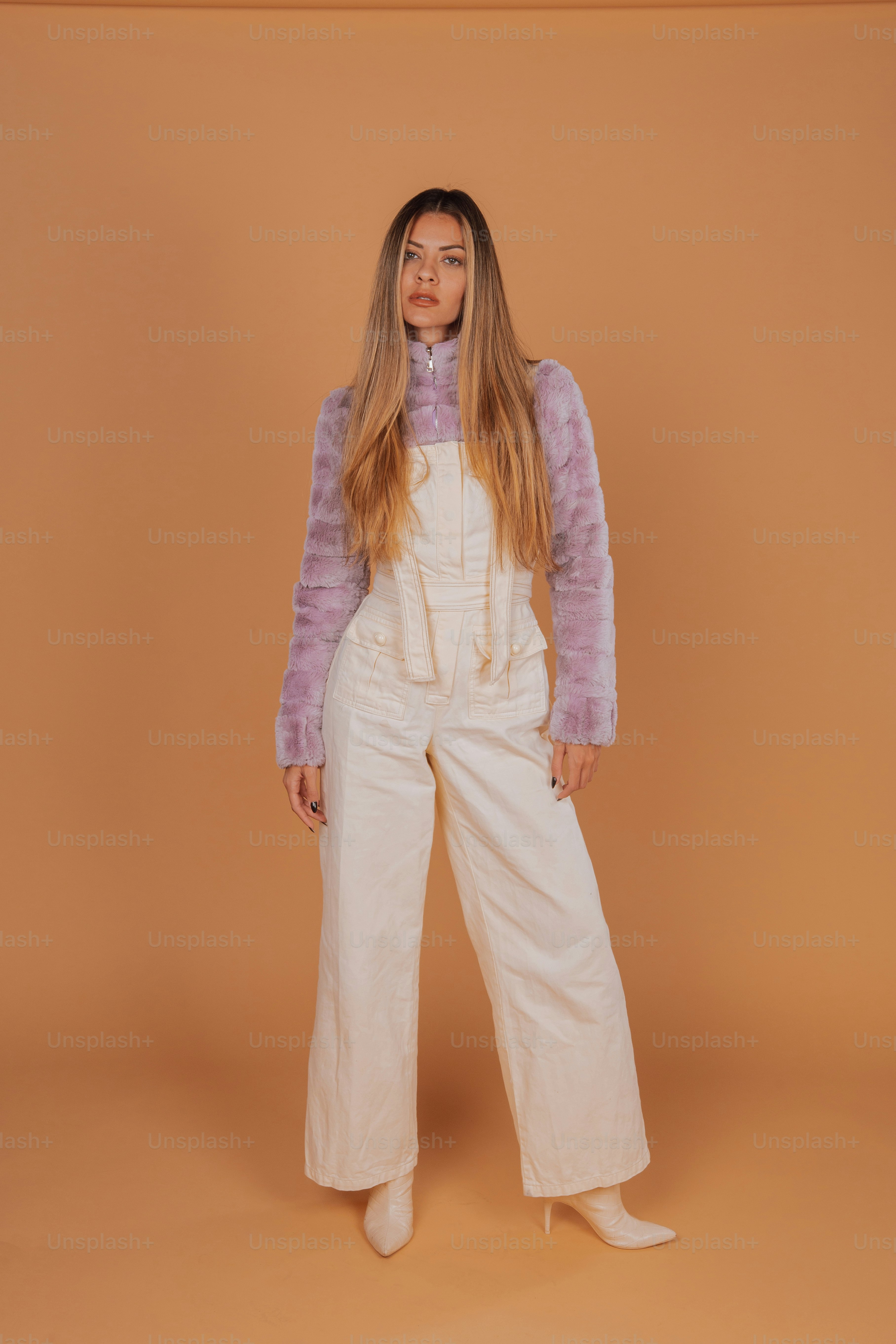 a woman standing in front of a brown background