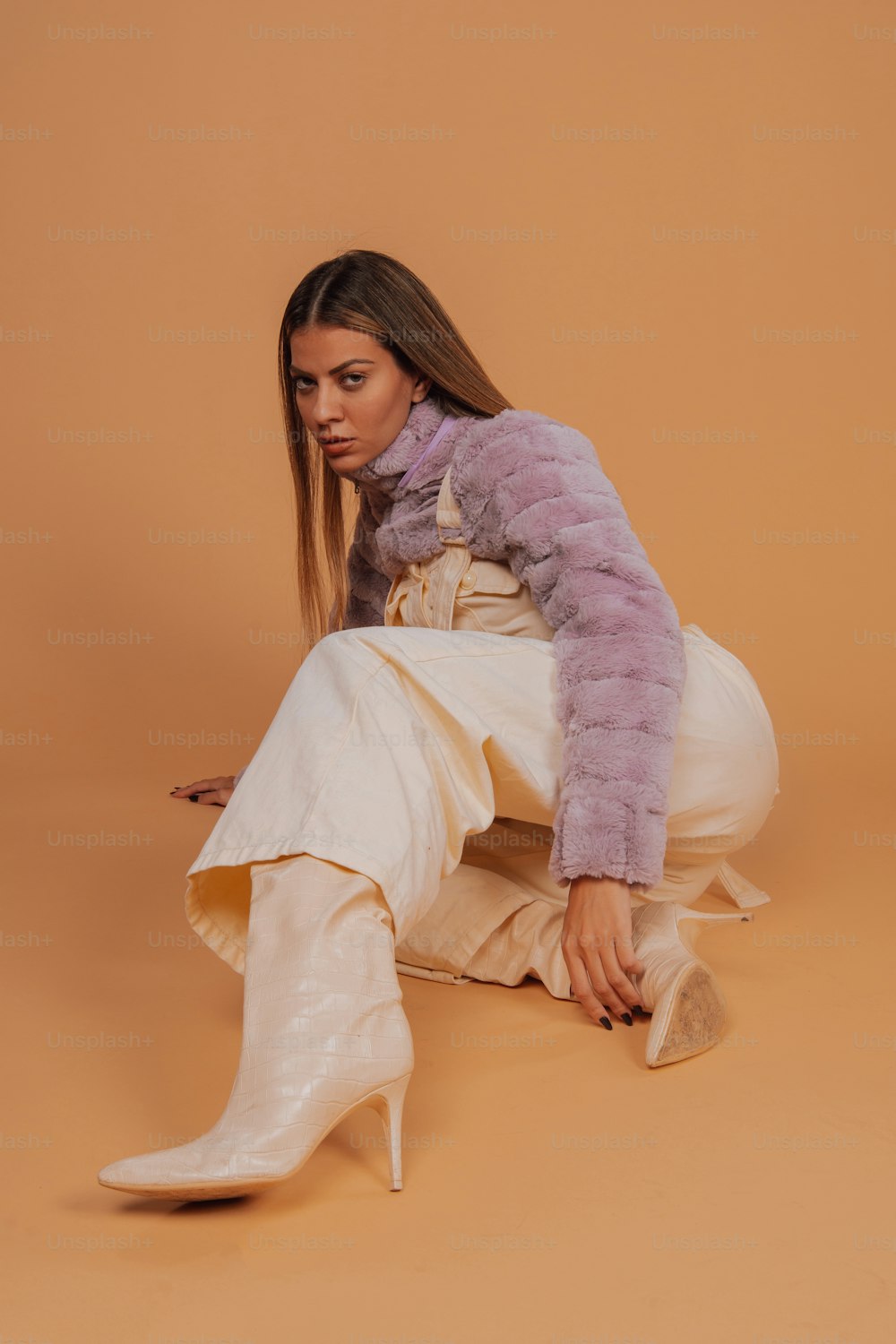 a woman sitting on the ground wearing high heels