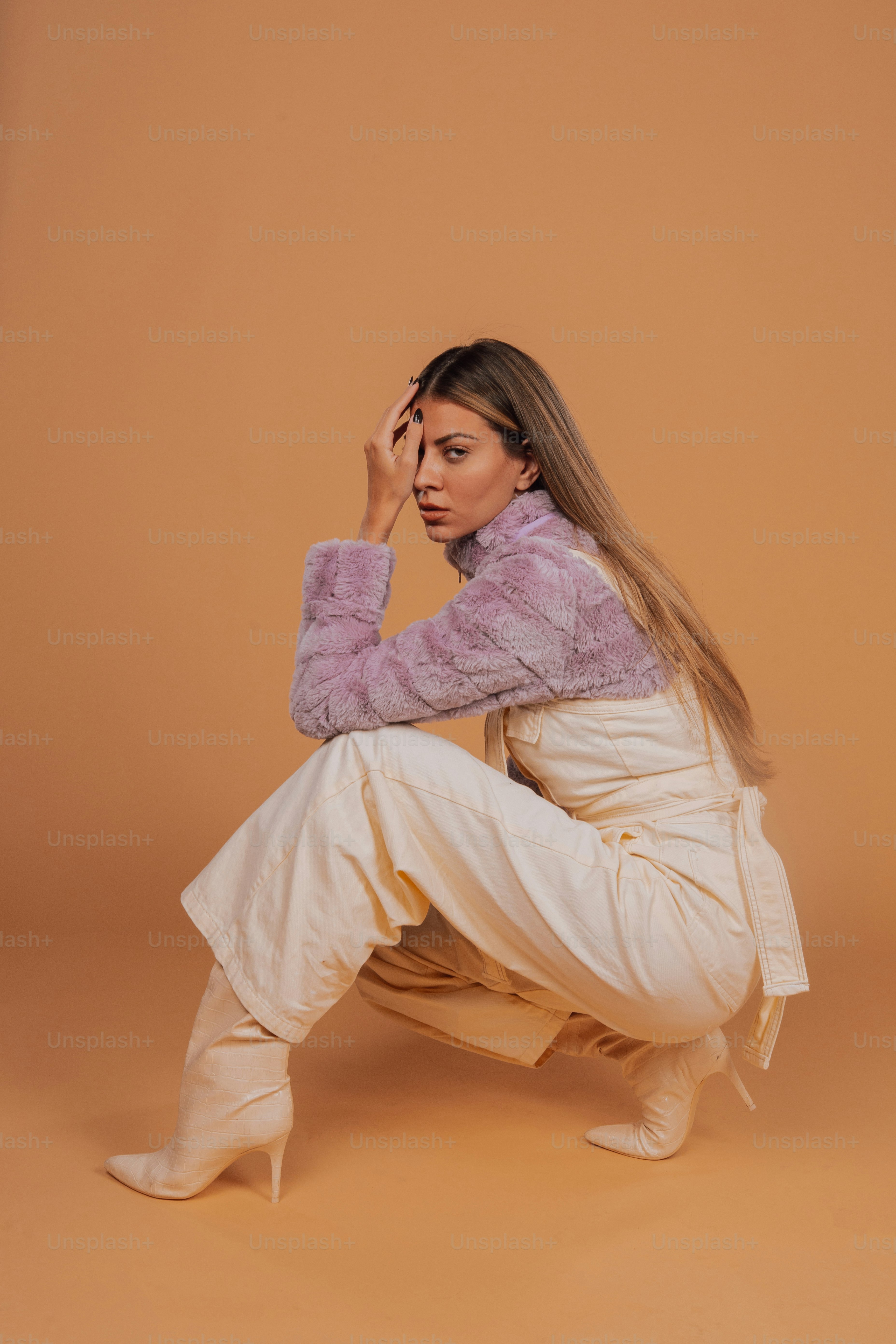 Eine Frau sitzt in einem weißen Outfit auf dem Boden