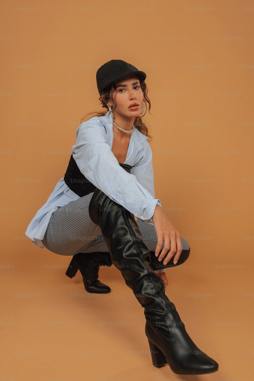 a woman sitting on the ground wearing black boots