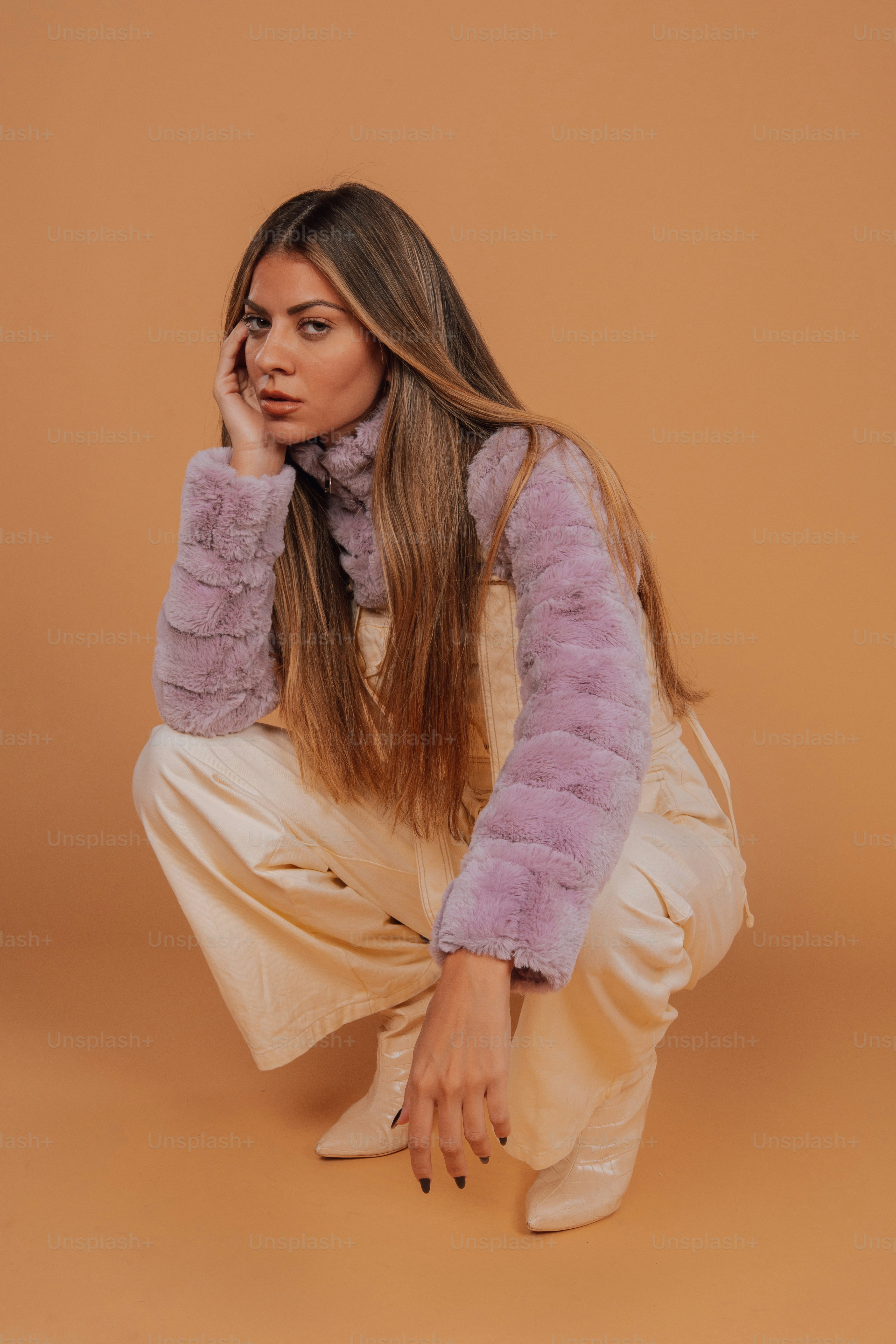 a woman is sitting on the floor with her hand on her face