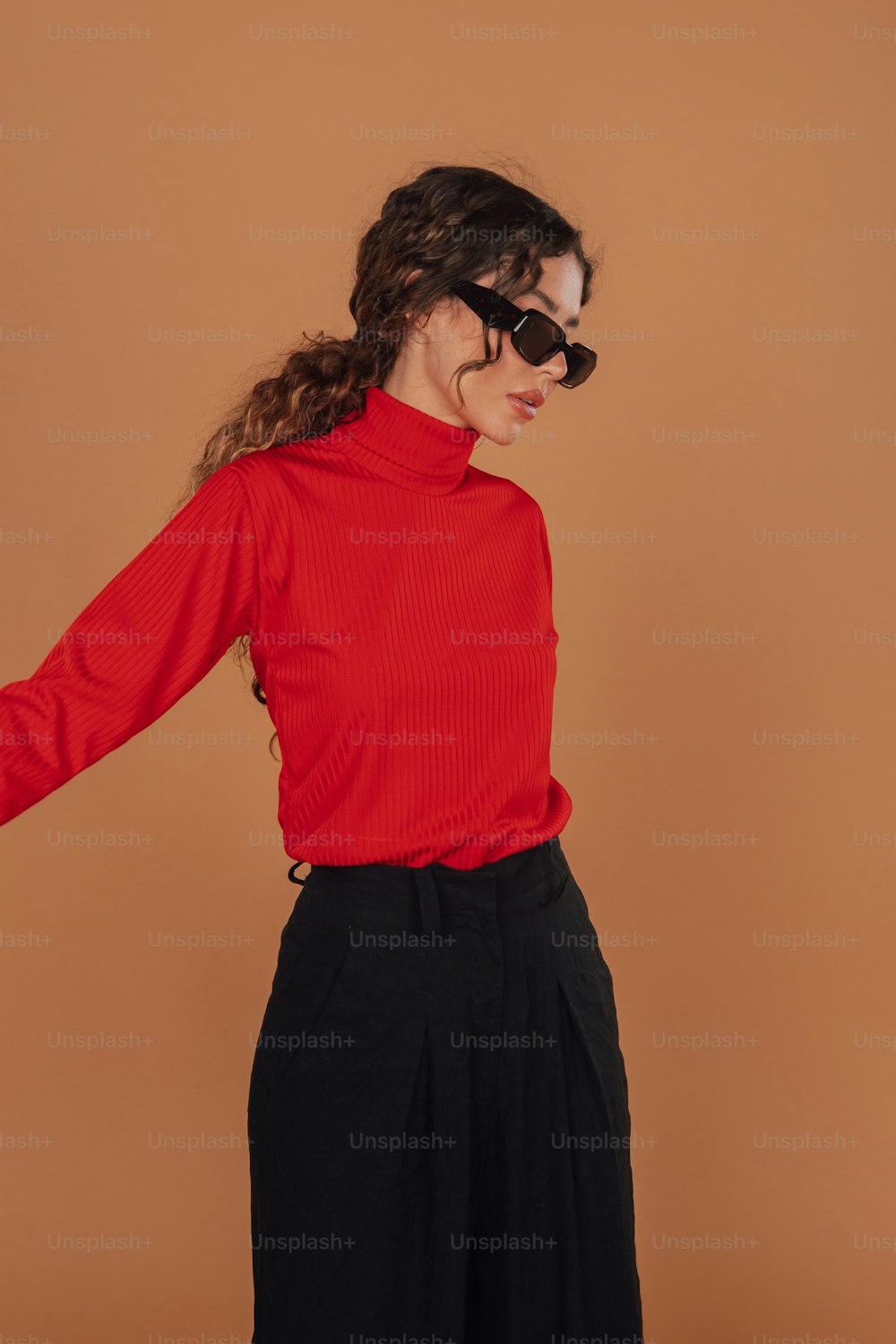 Una mujer con una camisa roja y pantalones negros
