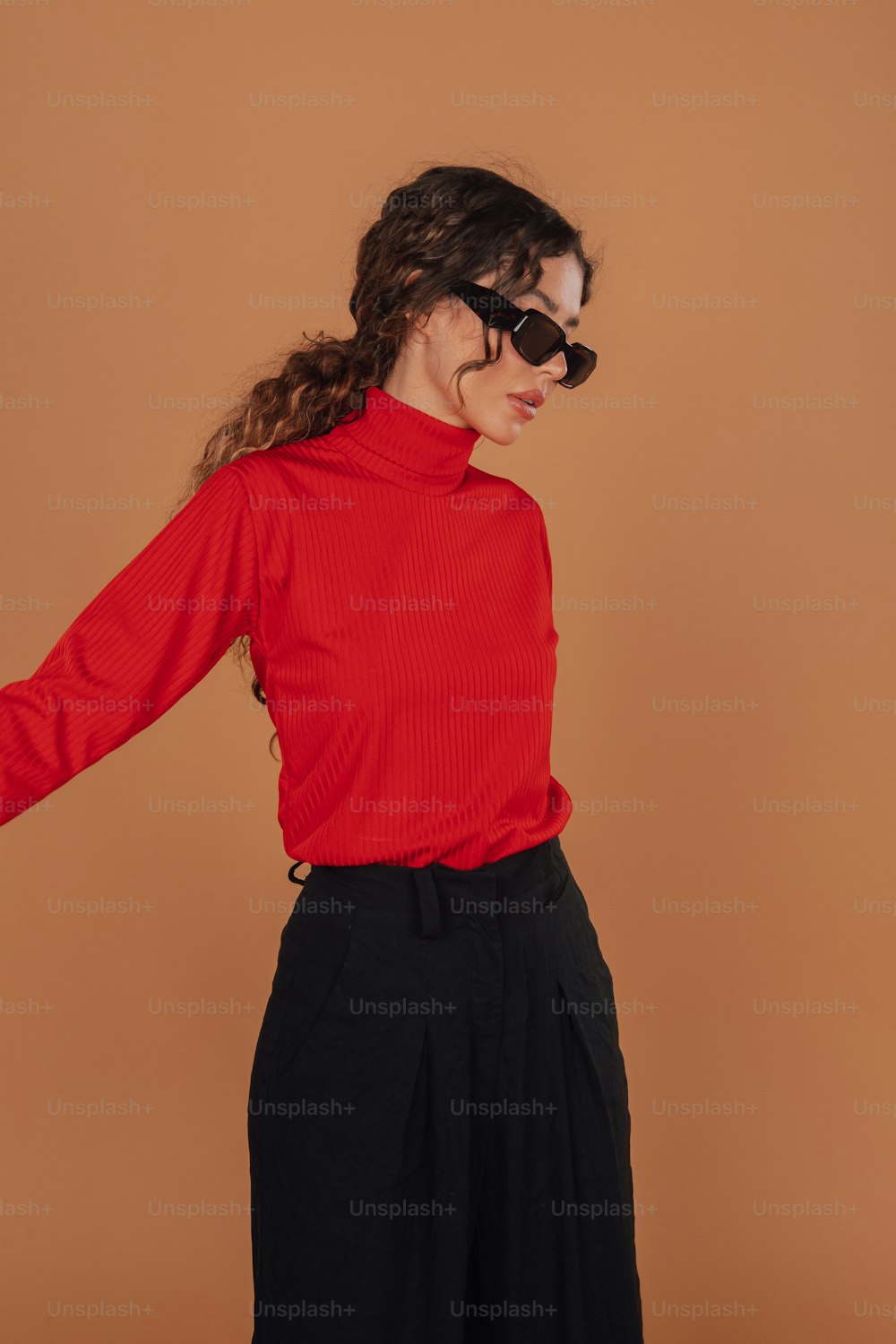 a woman wearing a red shirt and black pants