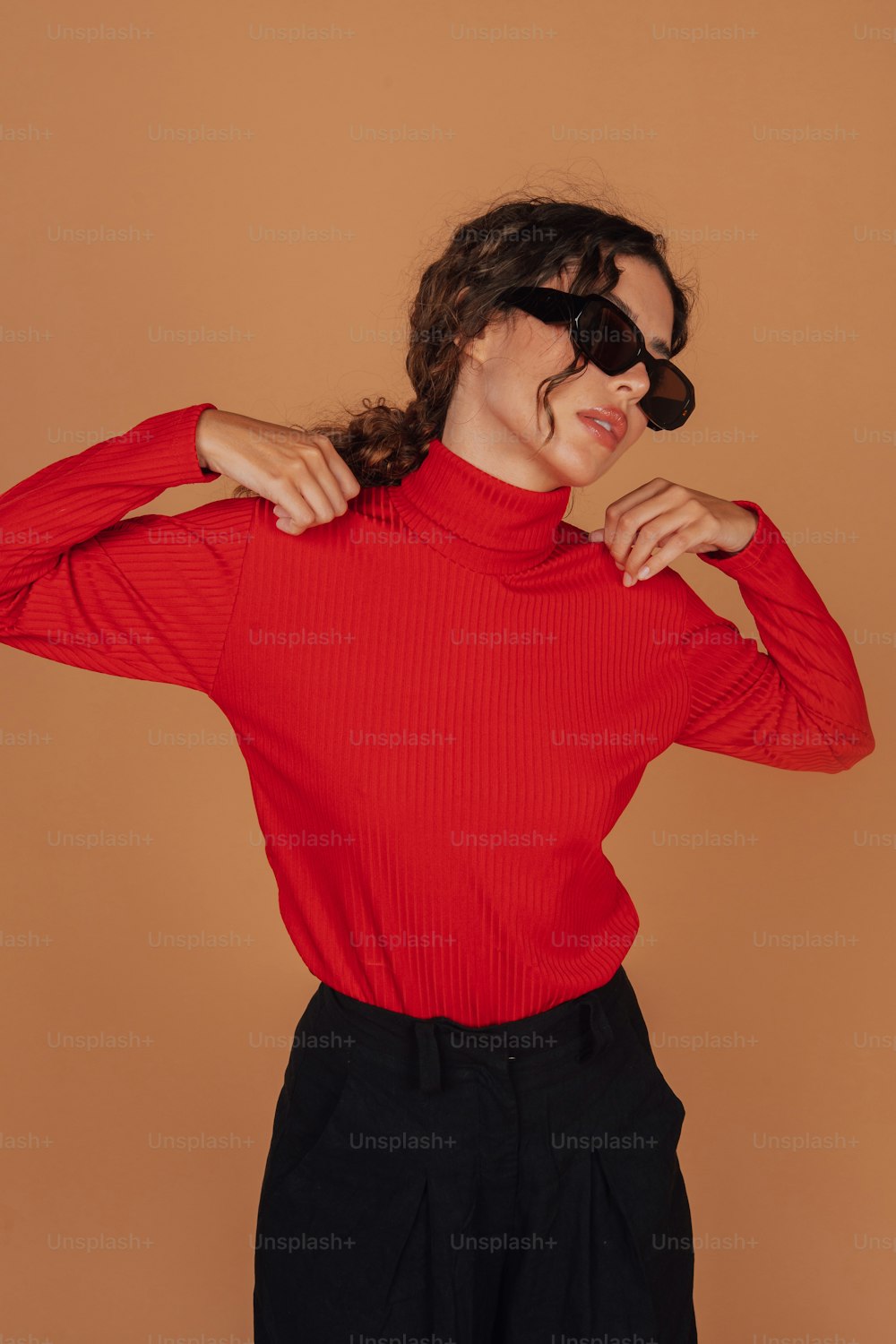 a woman wearing a red top and black pants