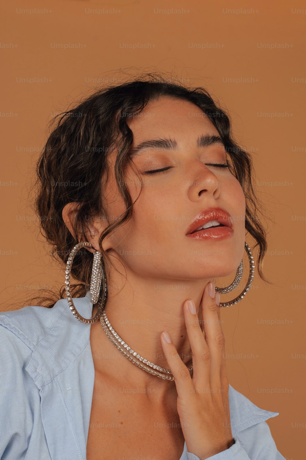 a woman with her eyes closed wearing large hoop earrings