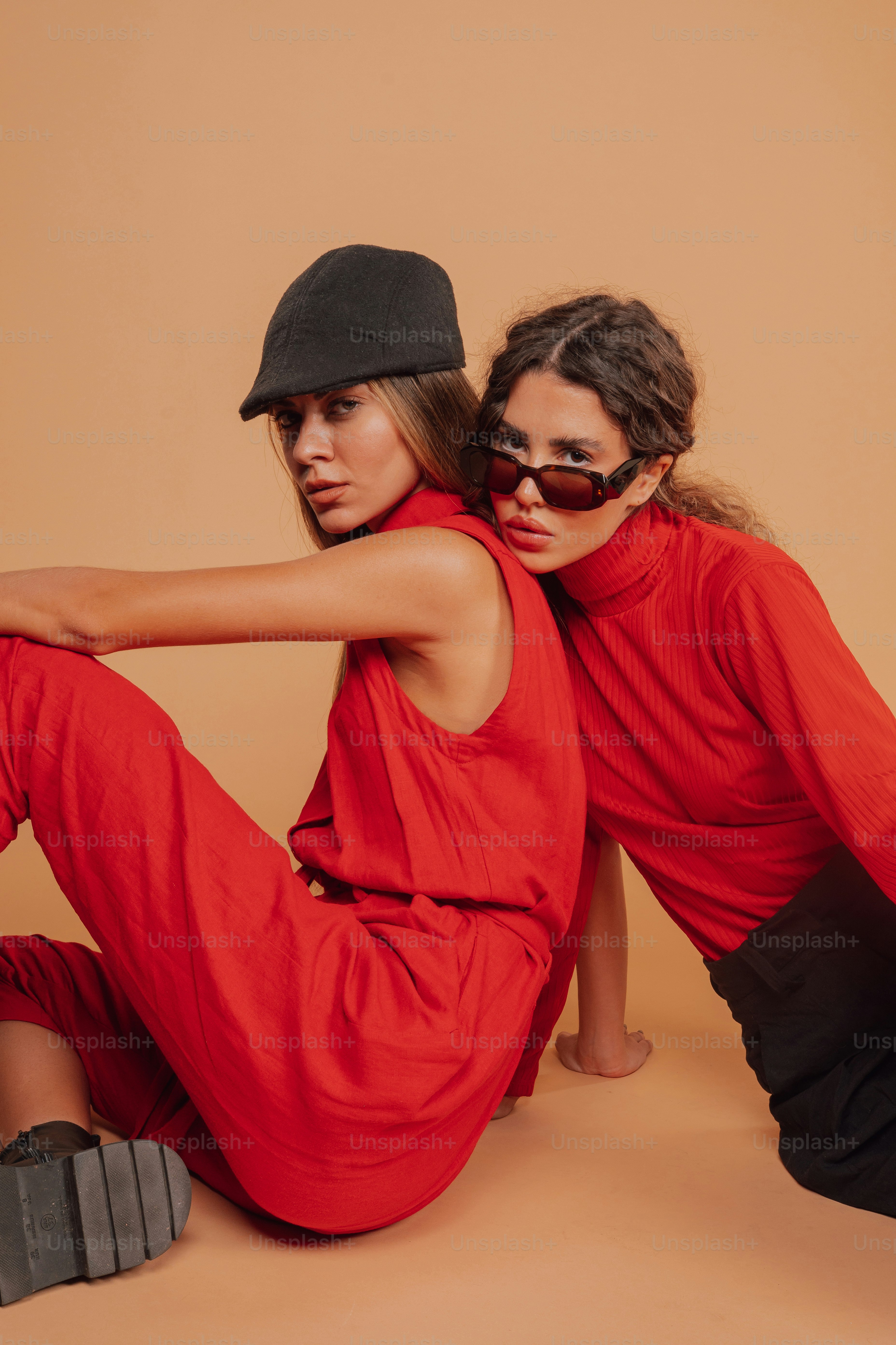 two women sitting on the ground with their arms around each other