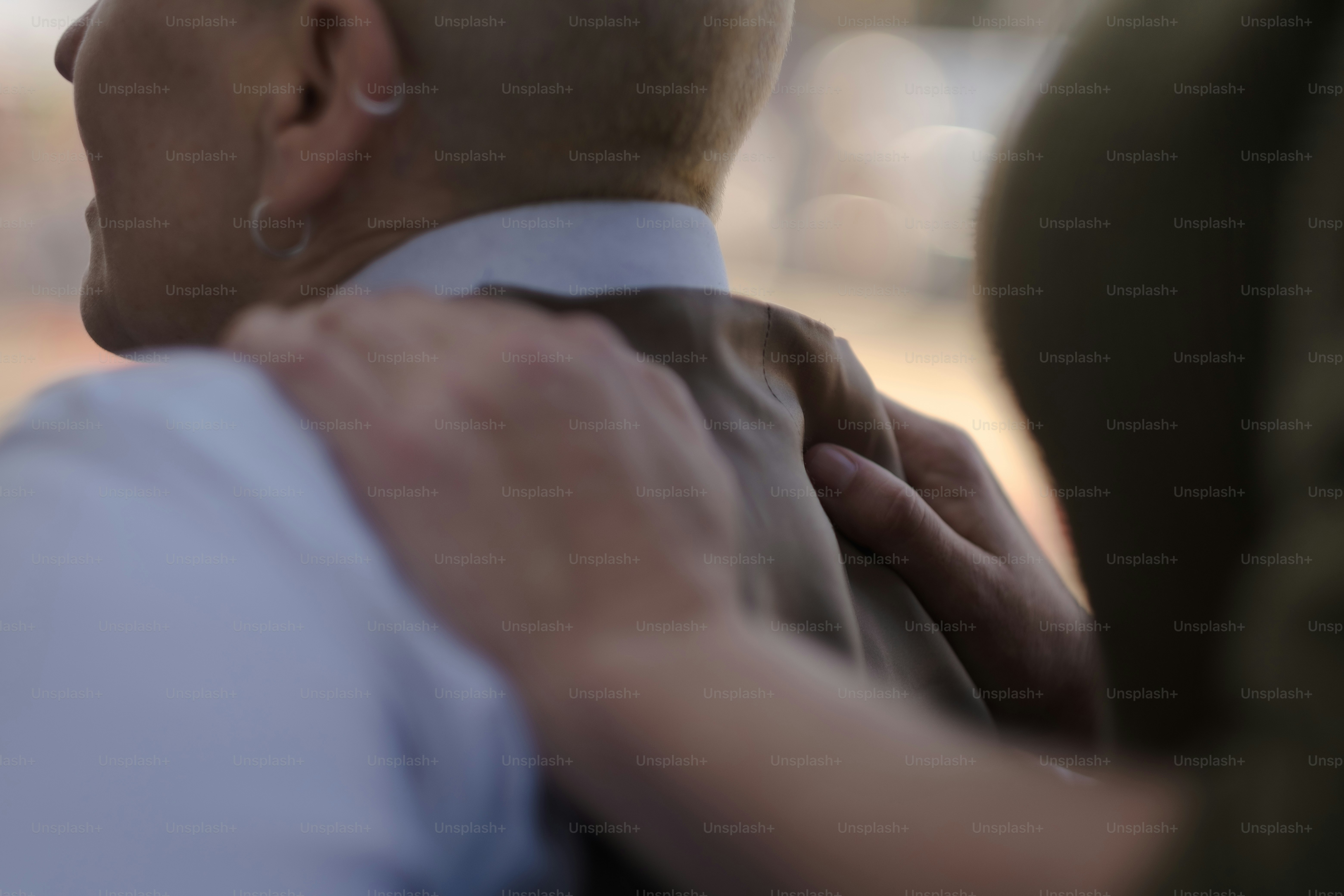 Un hombre con camisa blanca se está ajustando la corbata