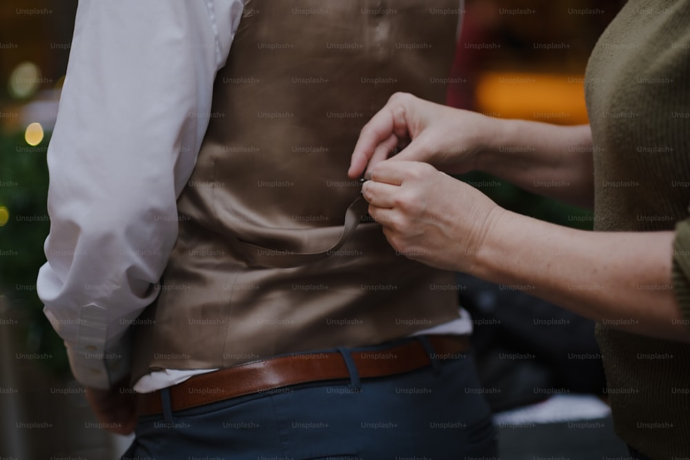 Eine Frau hilft einem Mann, seine Krawatte anzuziehen
