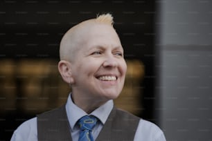 a man with a shaved head wearing a blue tie