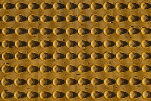 a close up of a yellow wall with circles on it