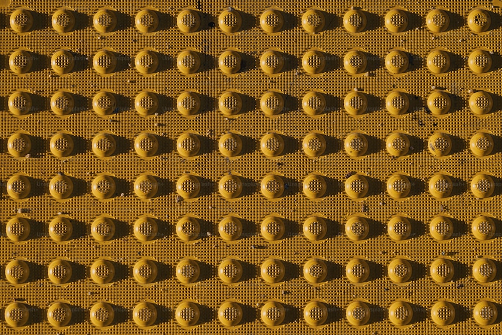 a close up of a yellow wall with circles on it