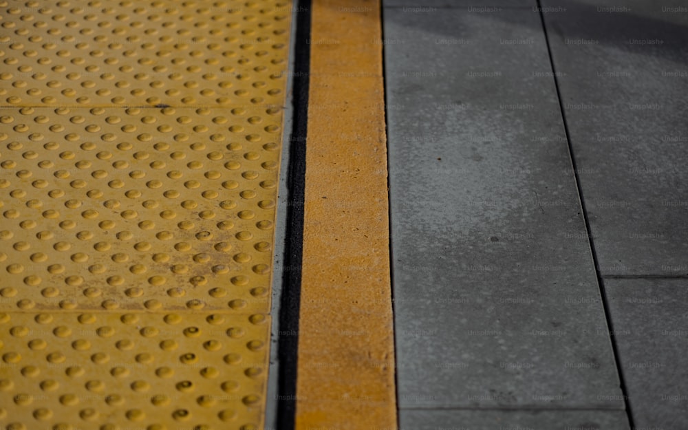 a close up of a yellow and black line on a street