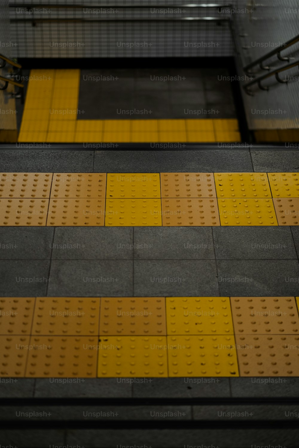 a train platform with yellow and black lines