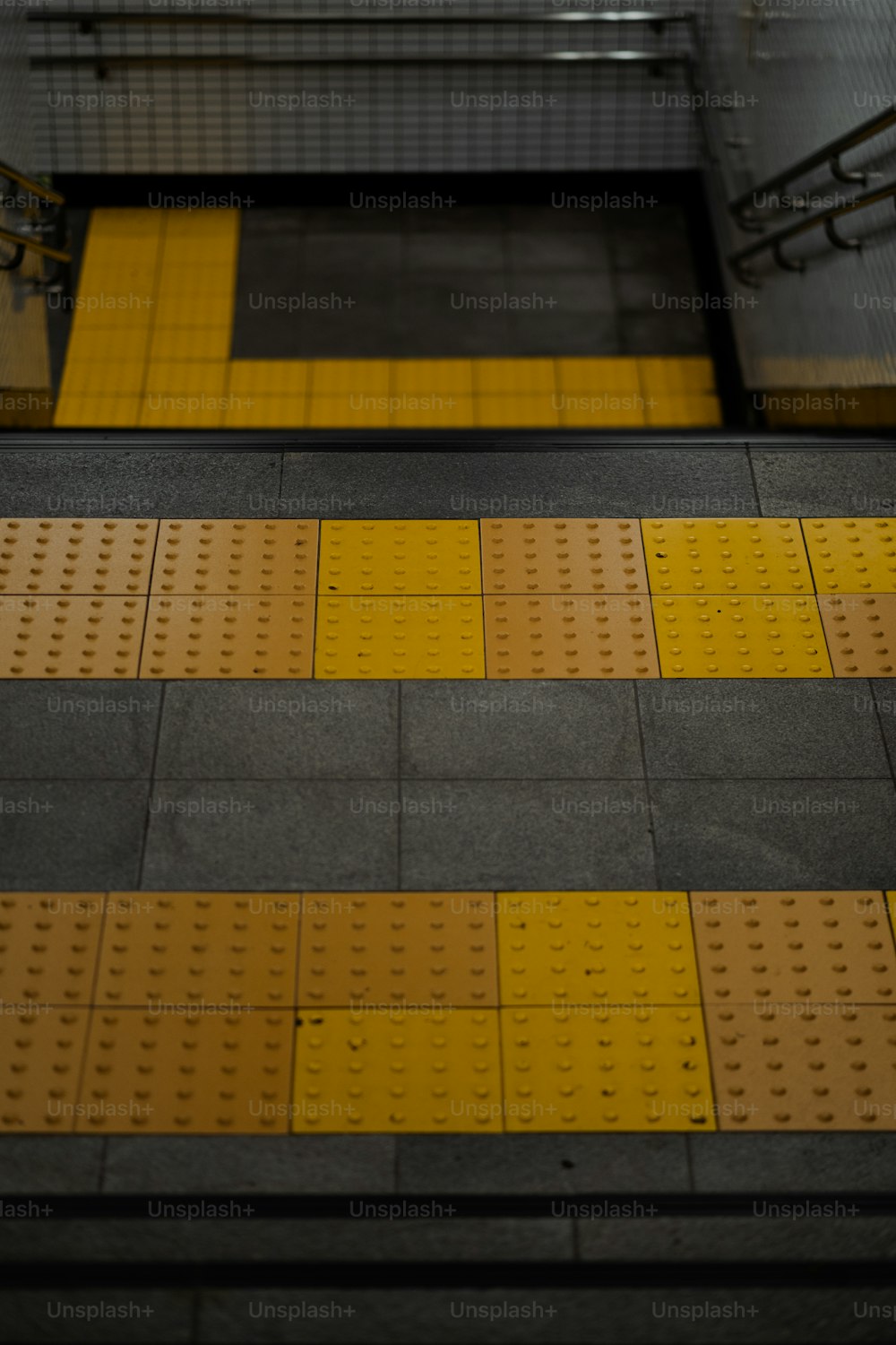 a train platform with yellow and black lines