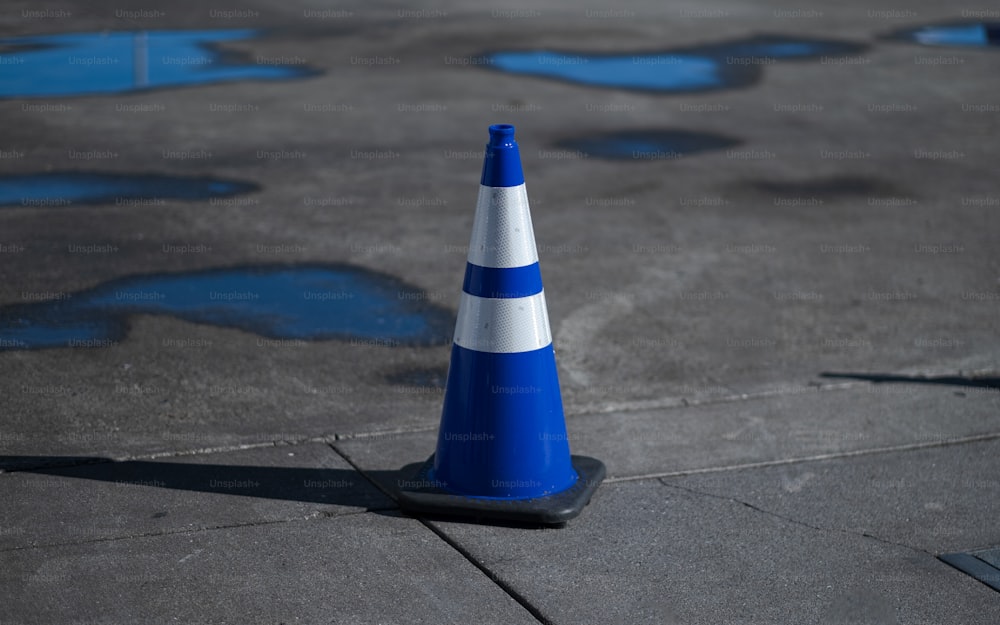 um cone azul e branco sentado em cima de uma calçada