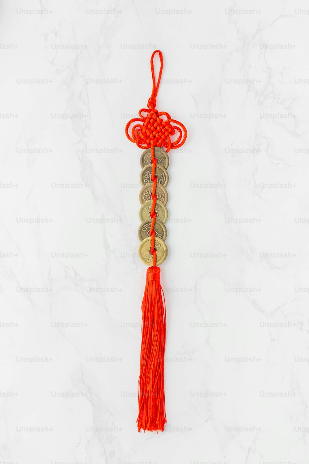a red tassel hanging on a white marble wall