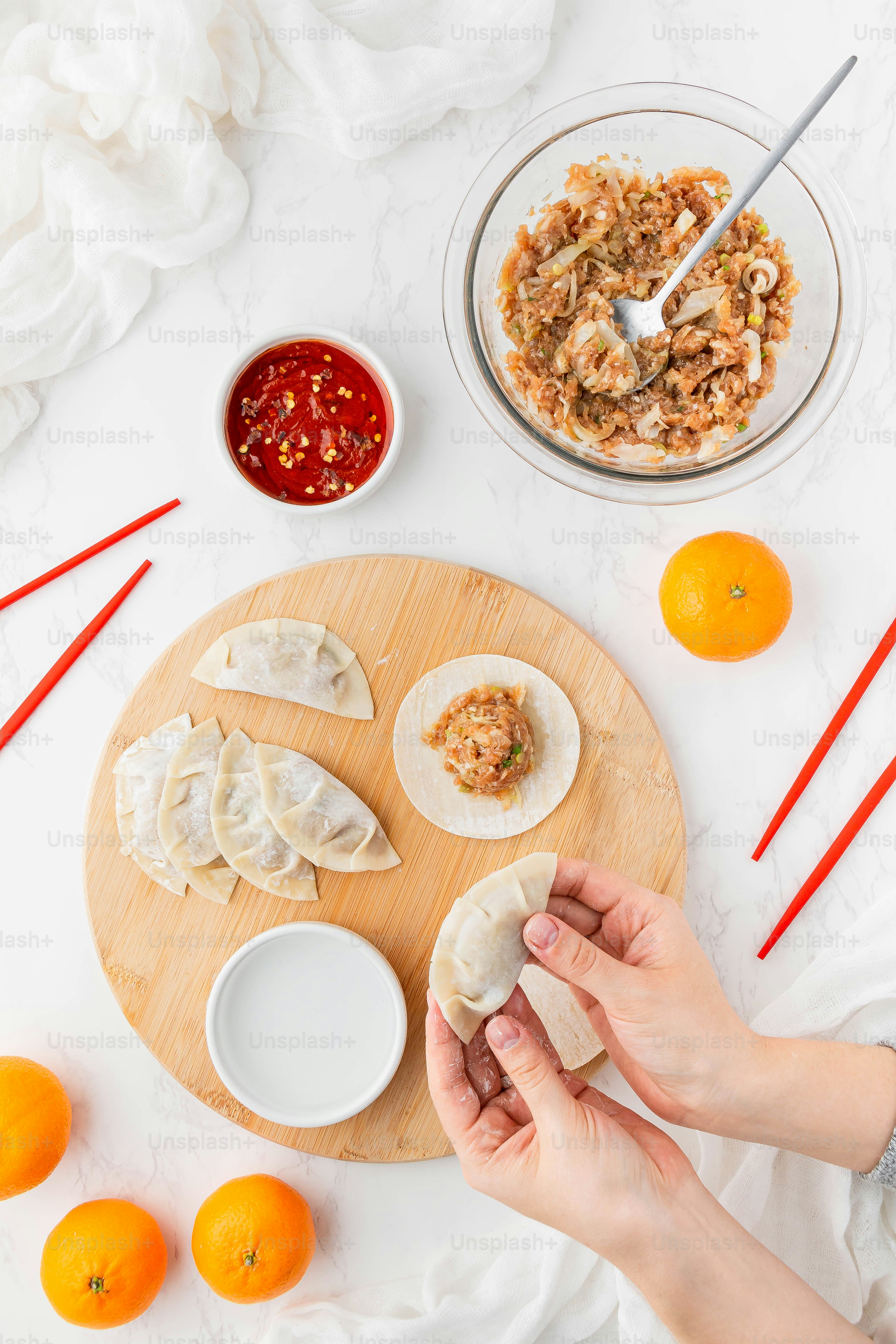a person holding a piece of food on top of a wooden cutting board