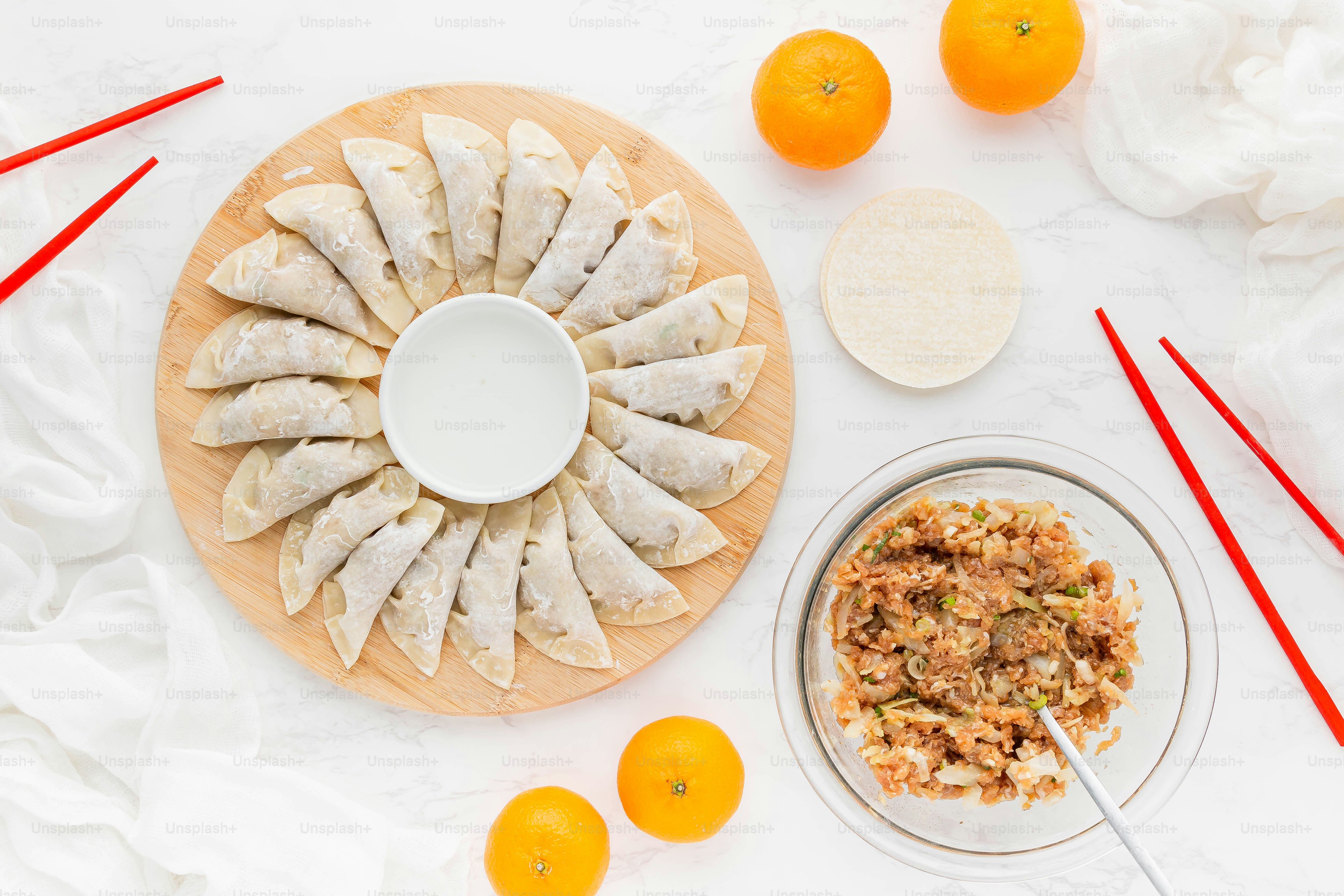 a plate of food with oranges and chopsticks next to it
