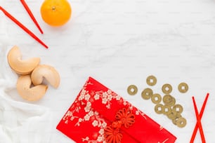 a white table topped with a red envelope next to oranges