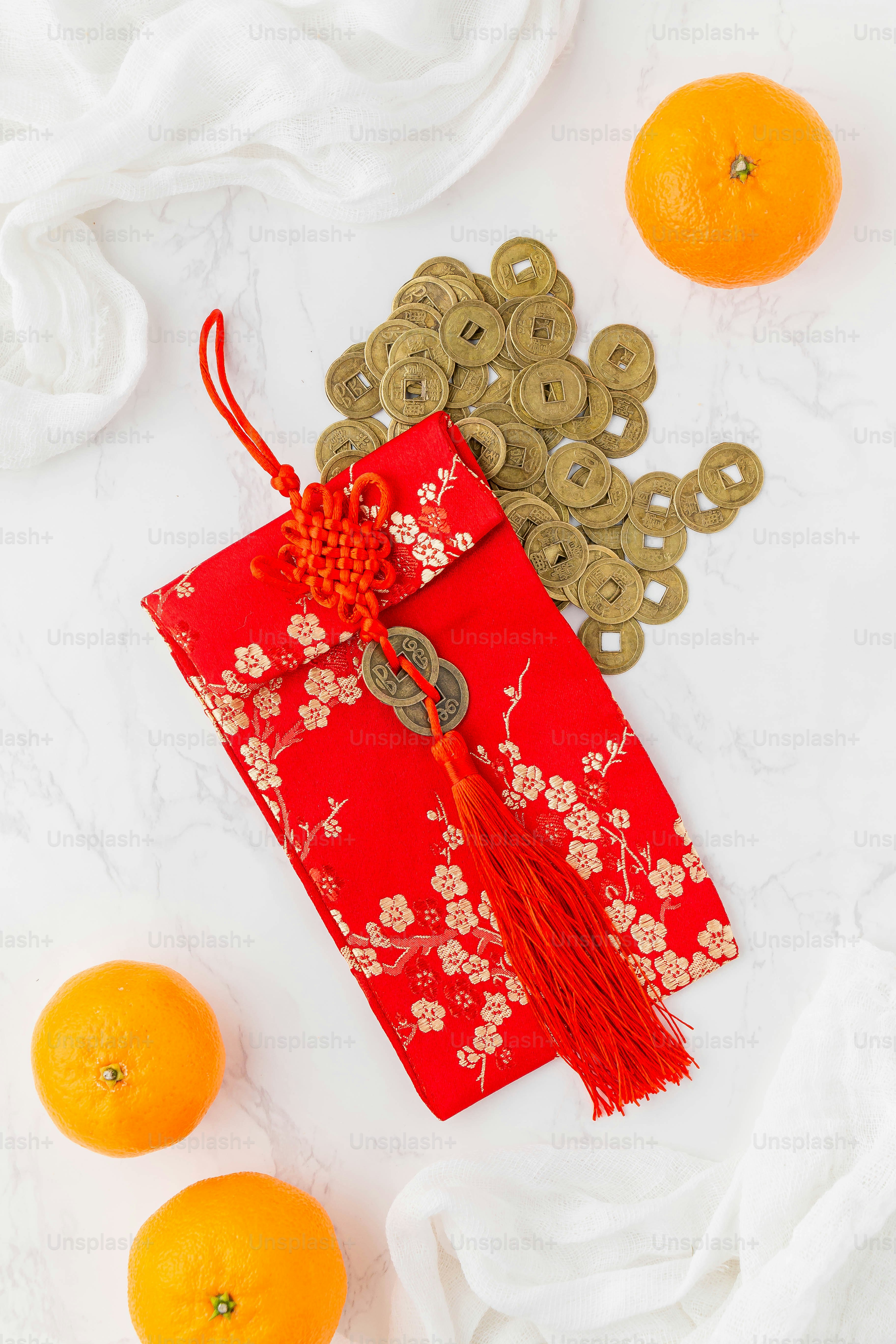 a red bag with a red tassel on top of it