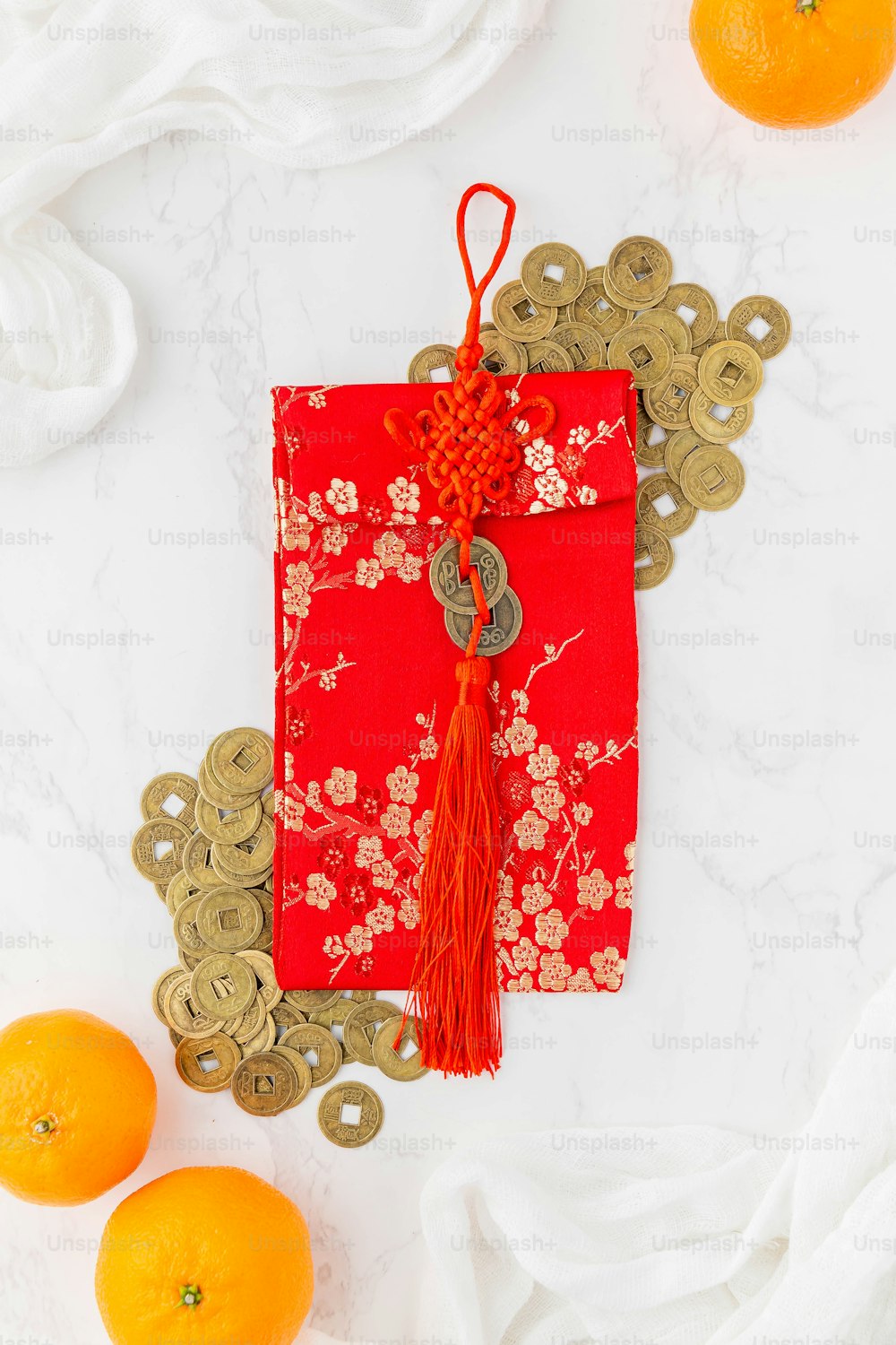 a red packet with a red tassel on top of it