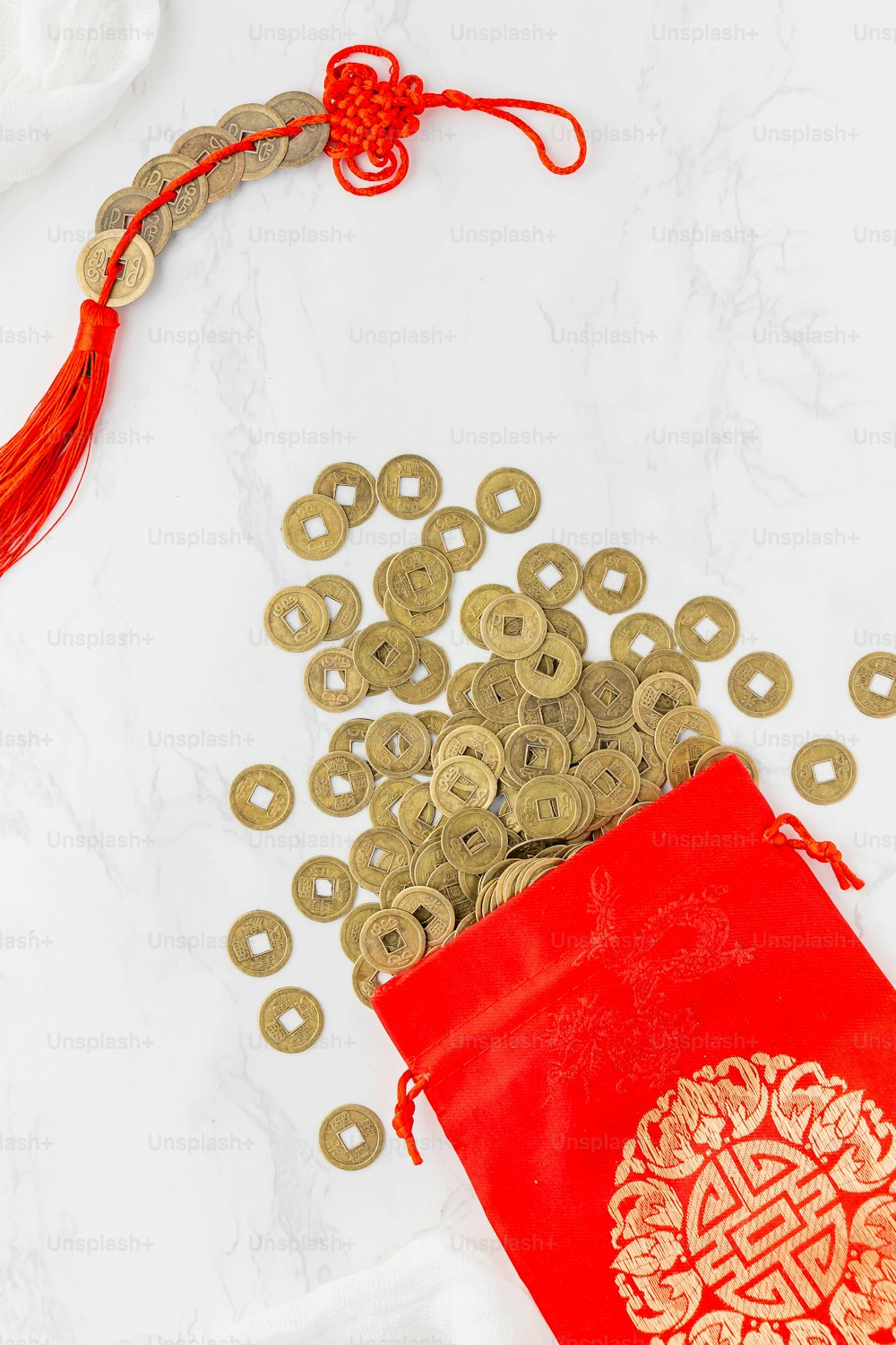 una borsa rossa piena di monete d'oro accanto a una borsa rossa piena di monete d'oro