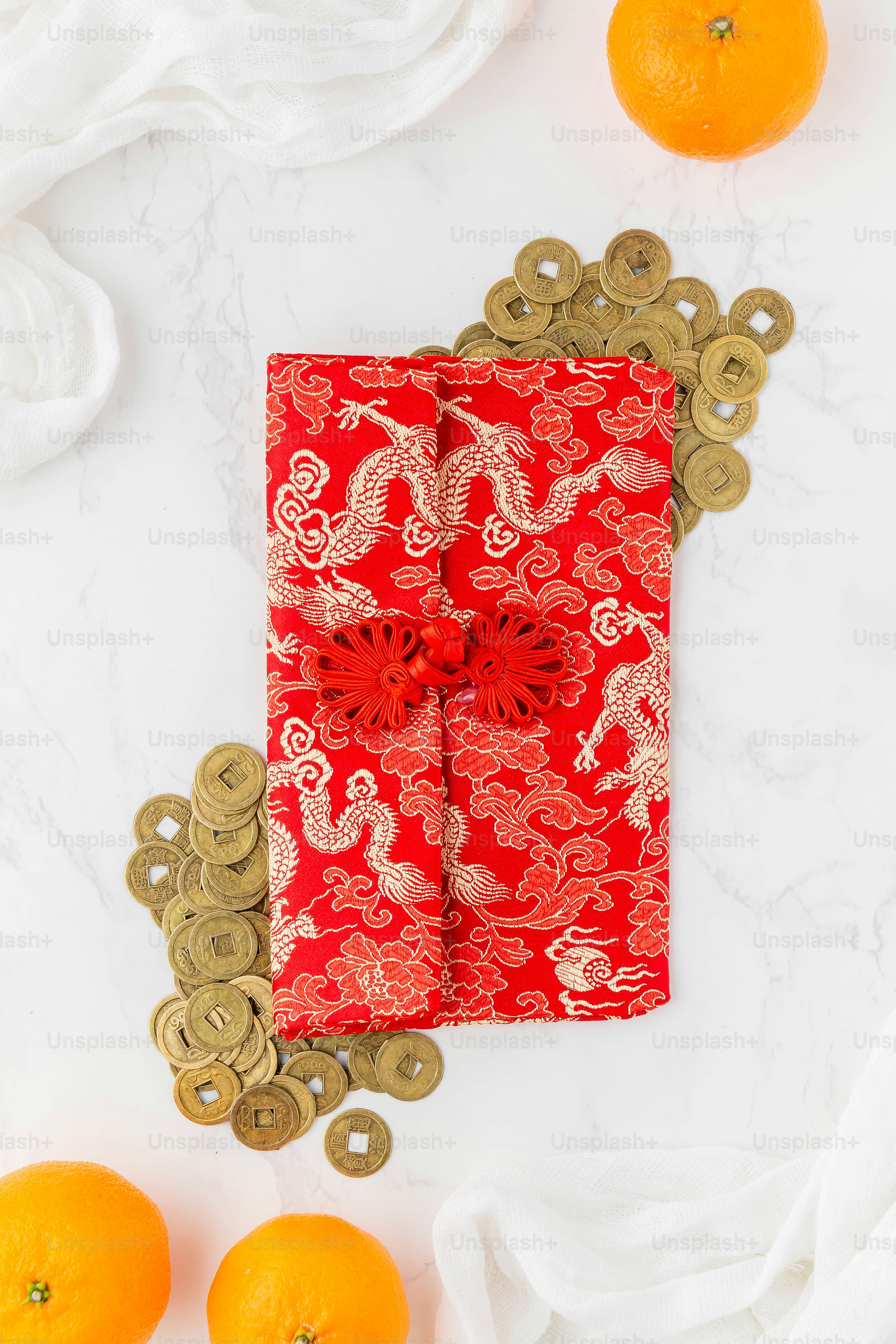 a red paper with a dragon design on it next to oranges