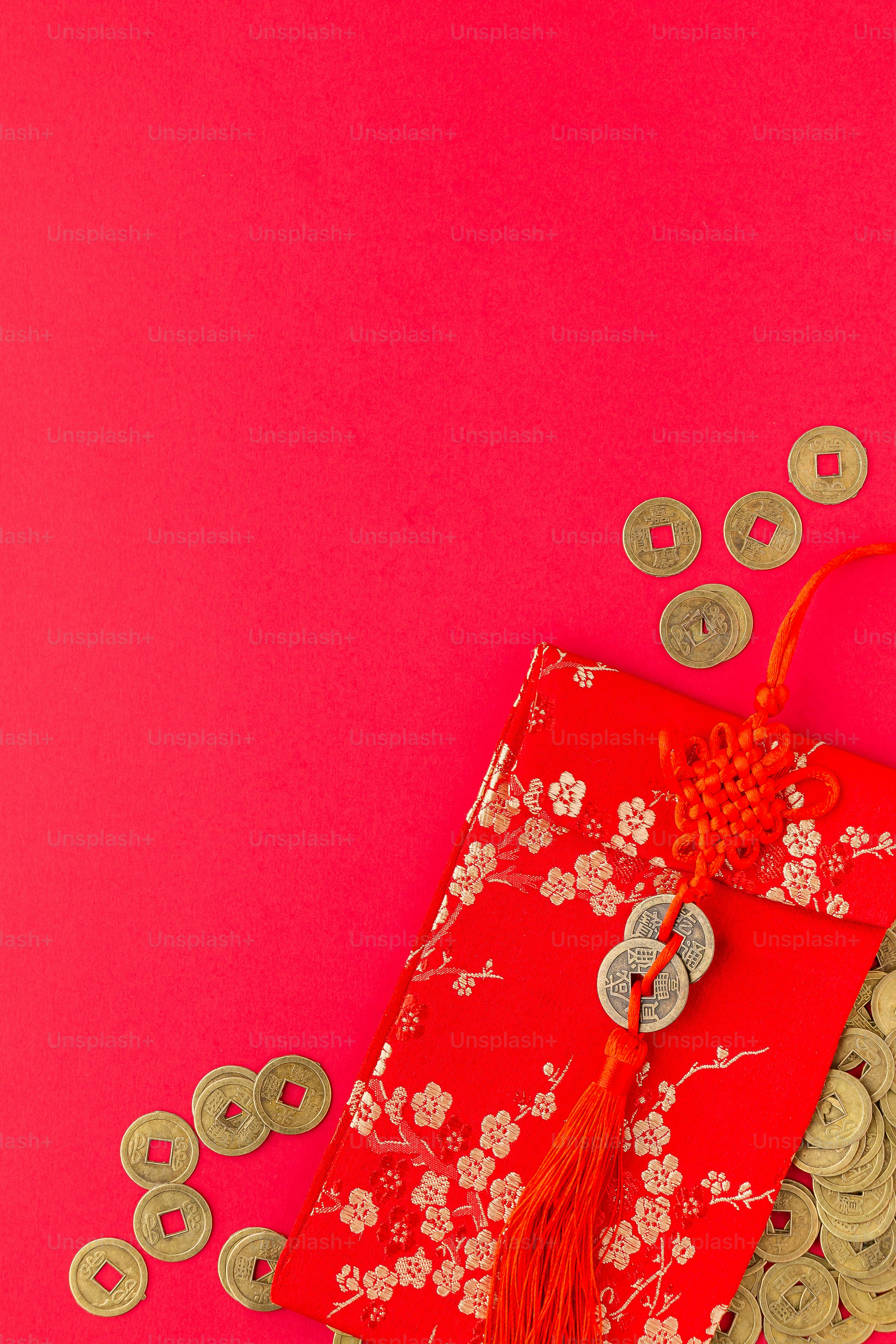 una borsa rossa con una nappa rossa e alcune monete